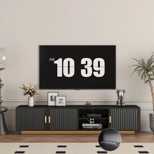 Modern black media console with fluted doors and gold accents