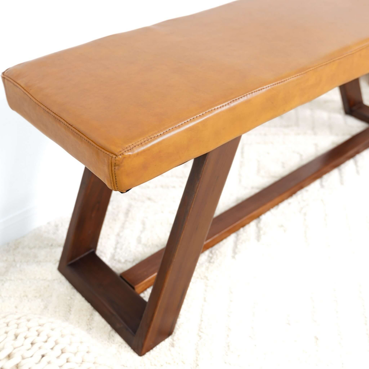 Tan leather bench with dark wood geometric base modern accent seating