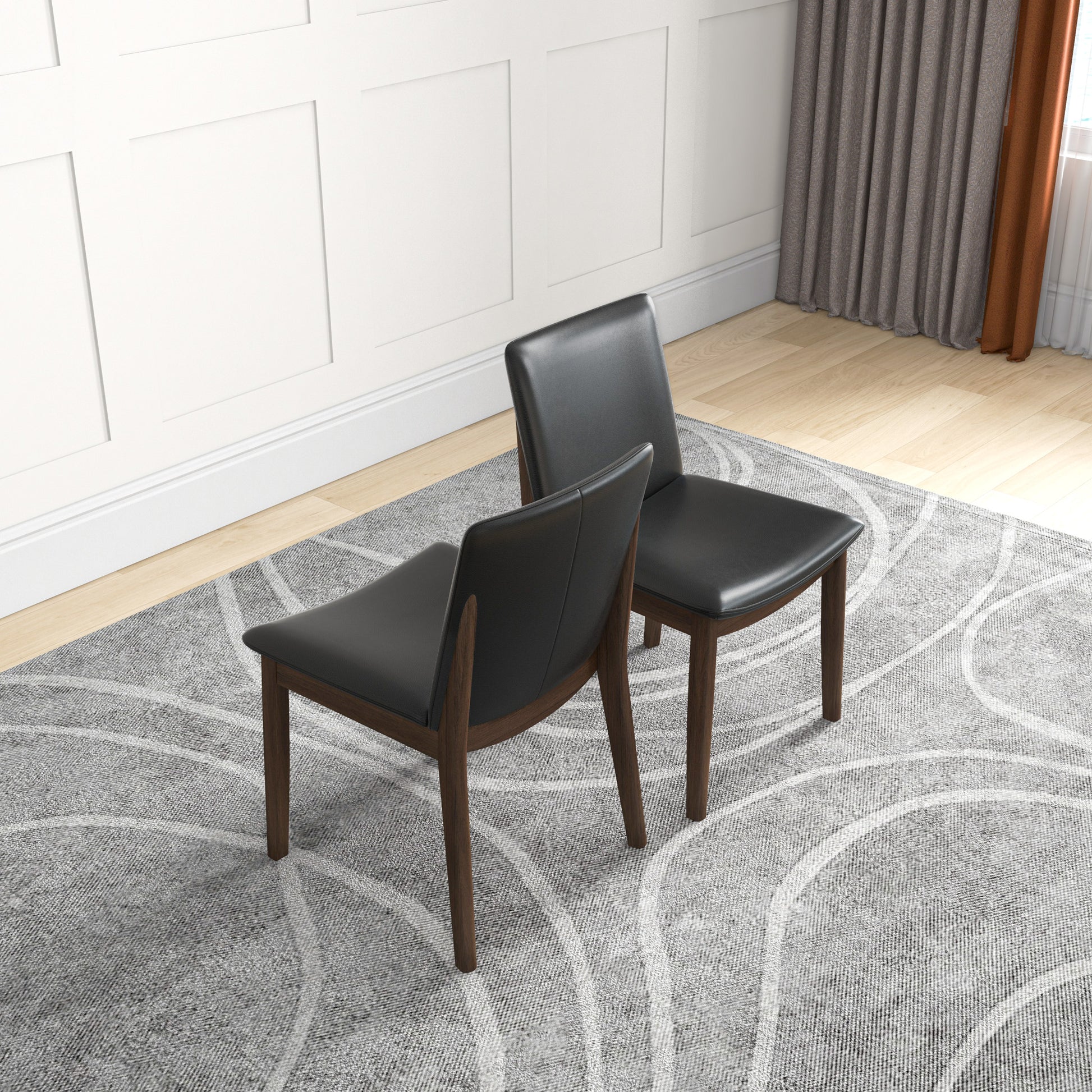 Two modern black faux leather dining chairs with dark wood legs on a grey abstract patterned rug