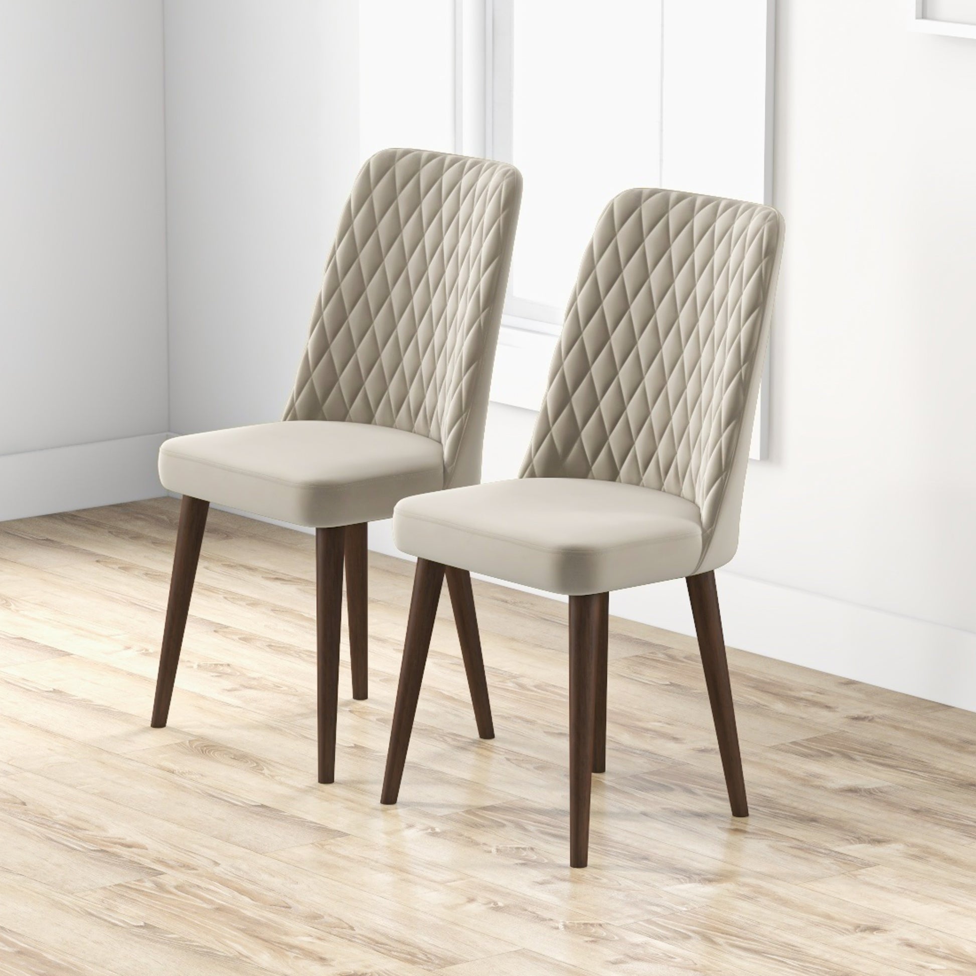 Two upholstered dining chairs in cream with diamond tufting and dark wood legs