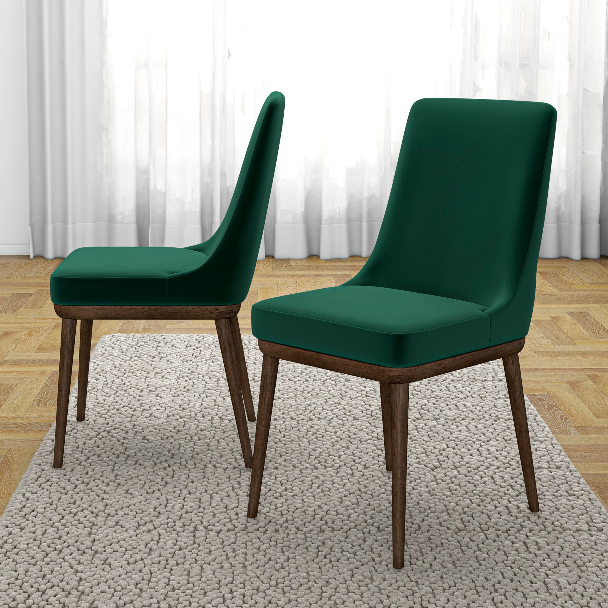 Two plush dark green velvet dining chairs with dark wood legs