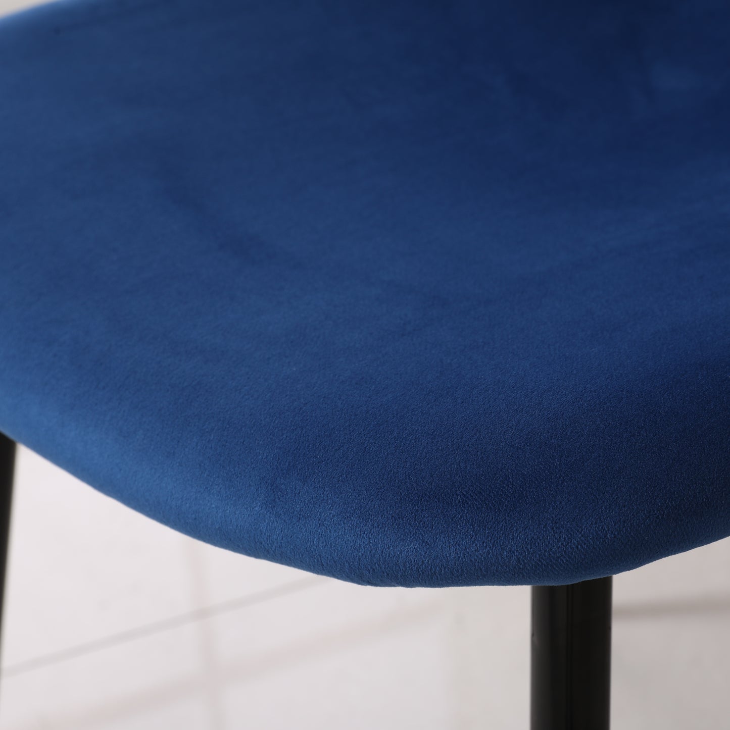 Closeup of plush navy blue velvet seat cushion on a chair