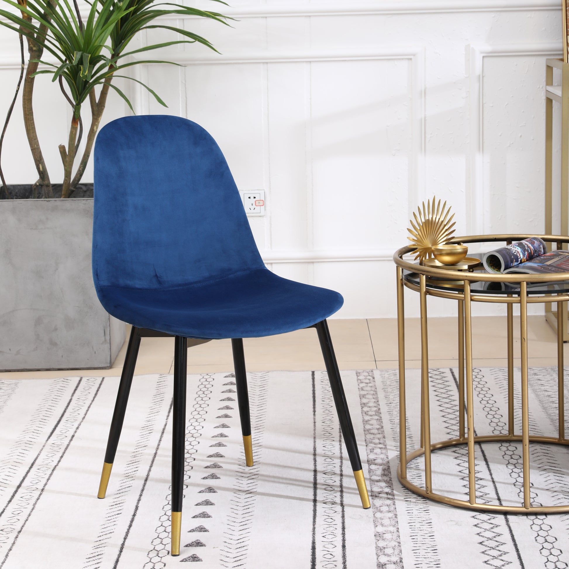 Deep blue velvet dining chair with black legs and gold accents perfect for modern interiors