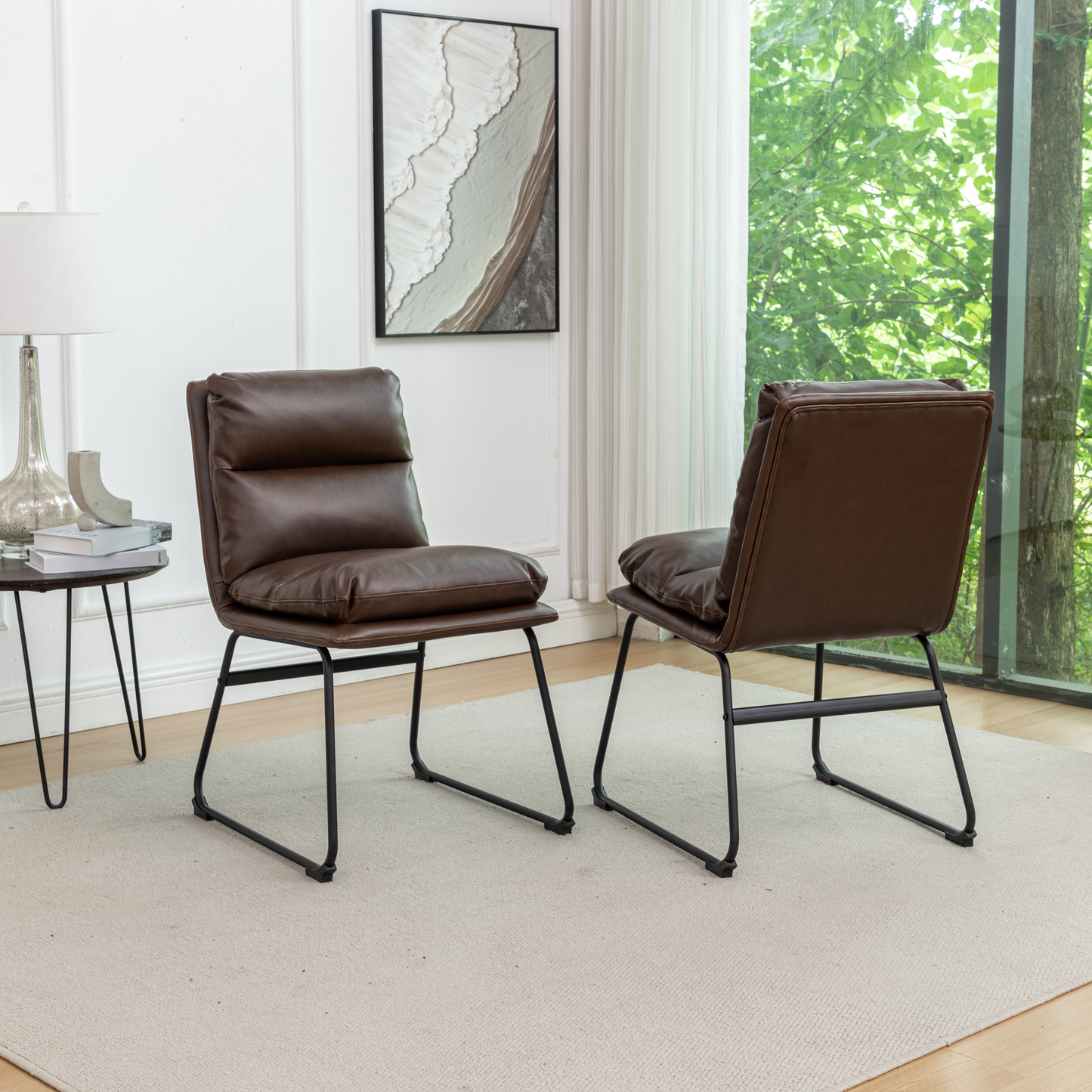 Two brown faux leather accent chairs with plush cushions and black metal legs
