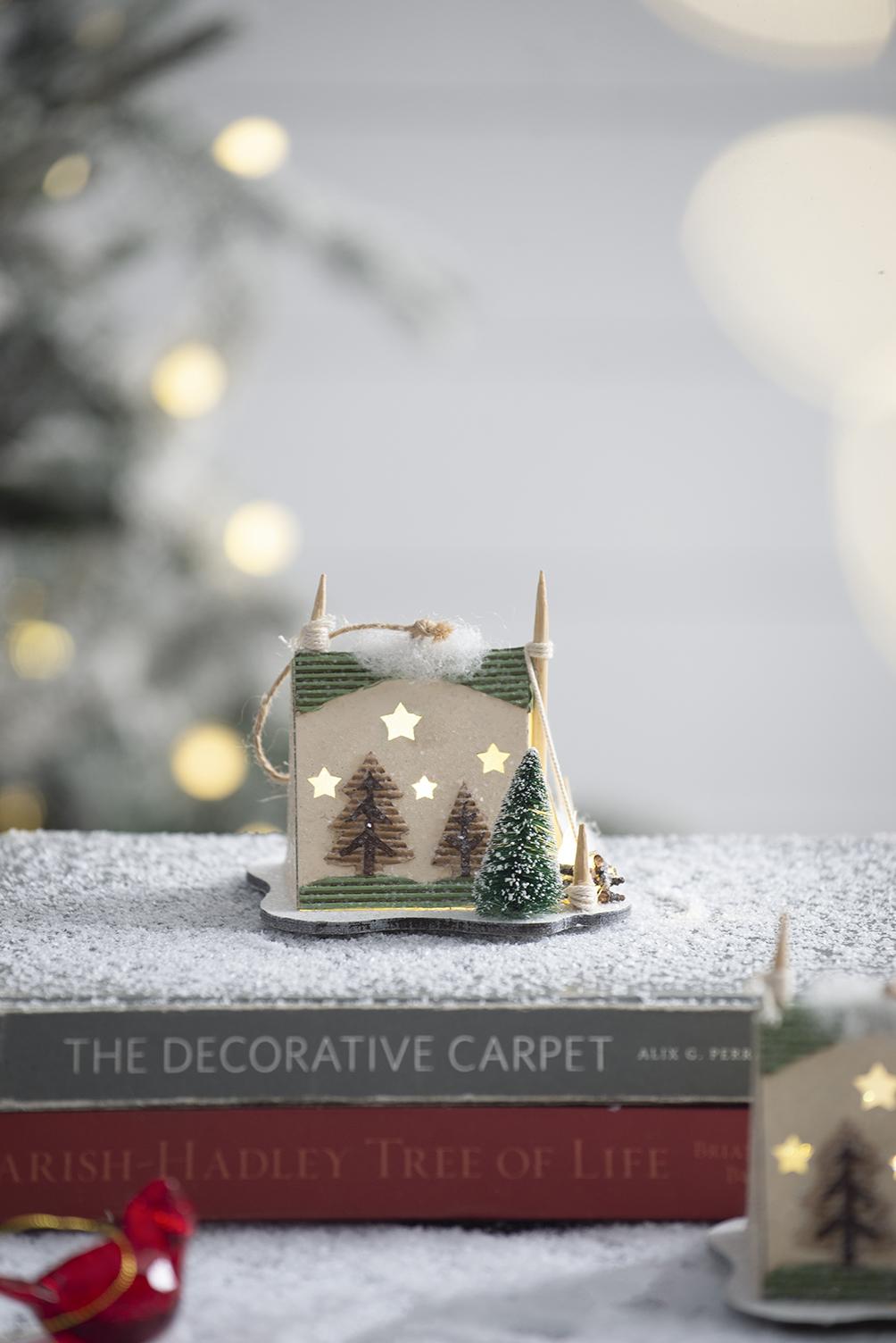 Lightup miniature wooden holiday cabin ornament with pine trees and stars