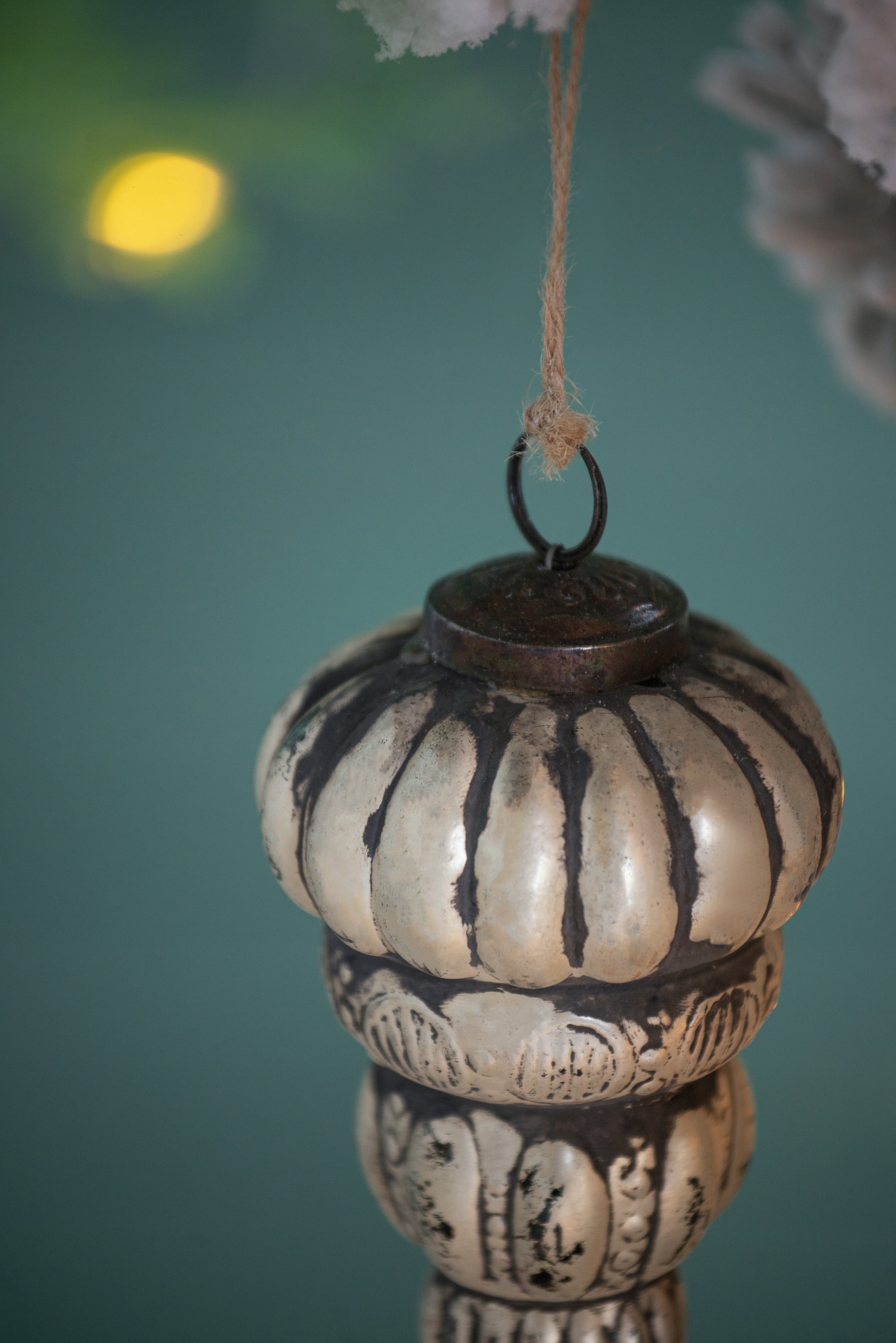 Antique silvertoned glass Christmas ornament with black detailing featuring ribbed segments and intricate patterns