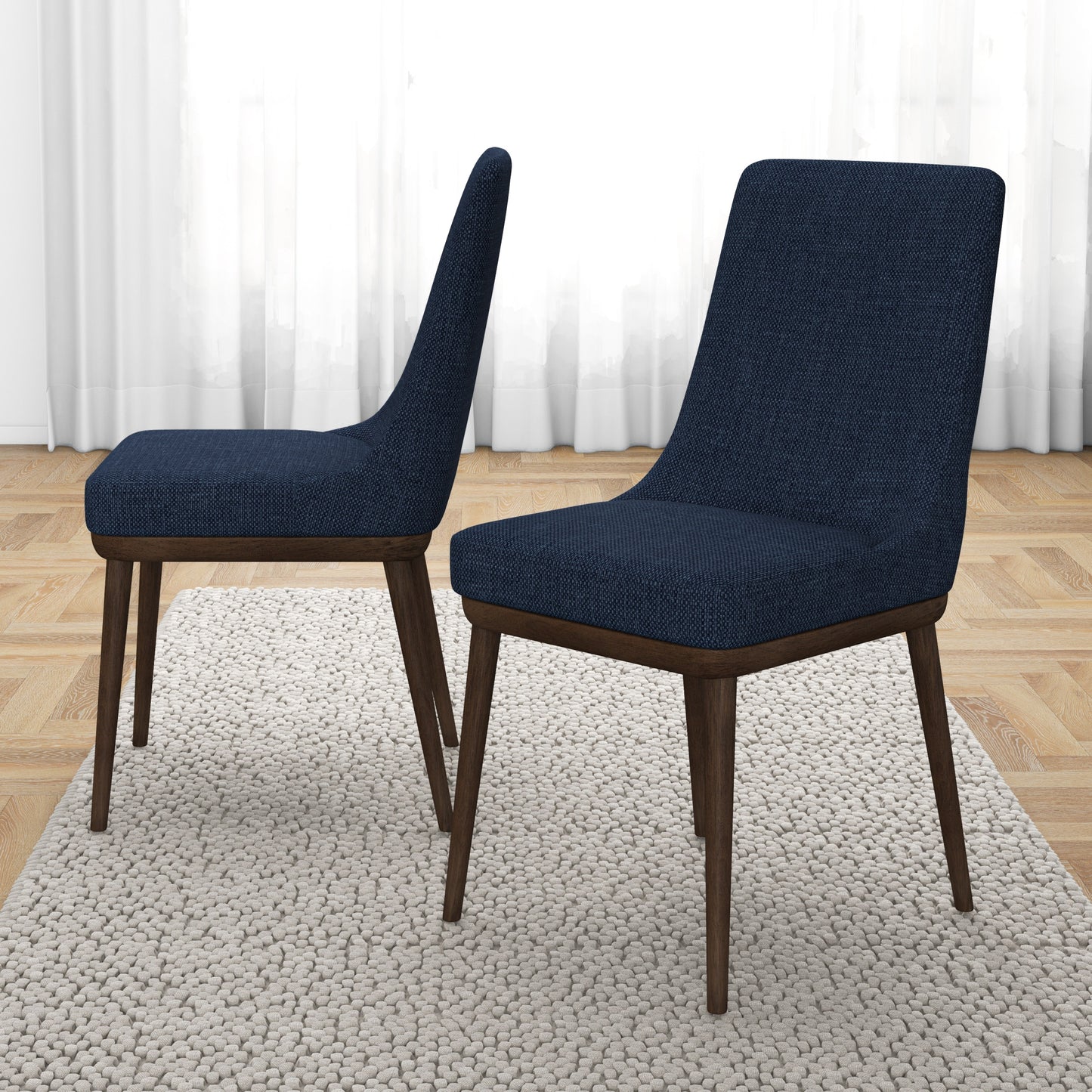Two upholstered dining chairs with dark blue fabric and tapered wooden legs