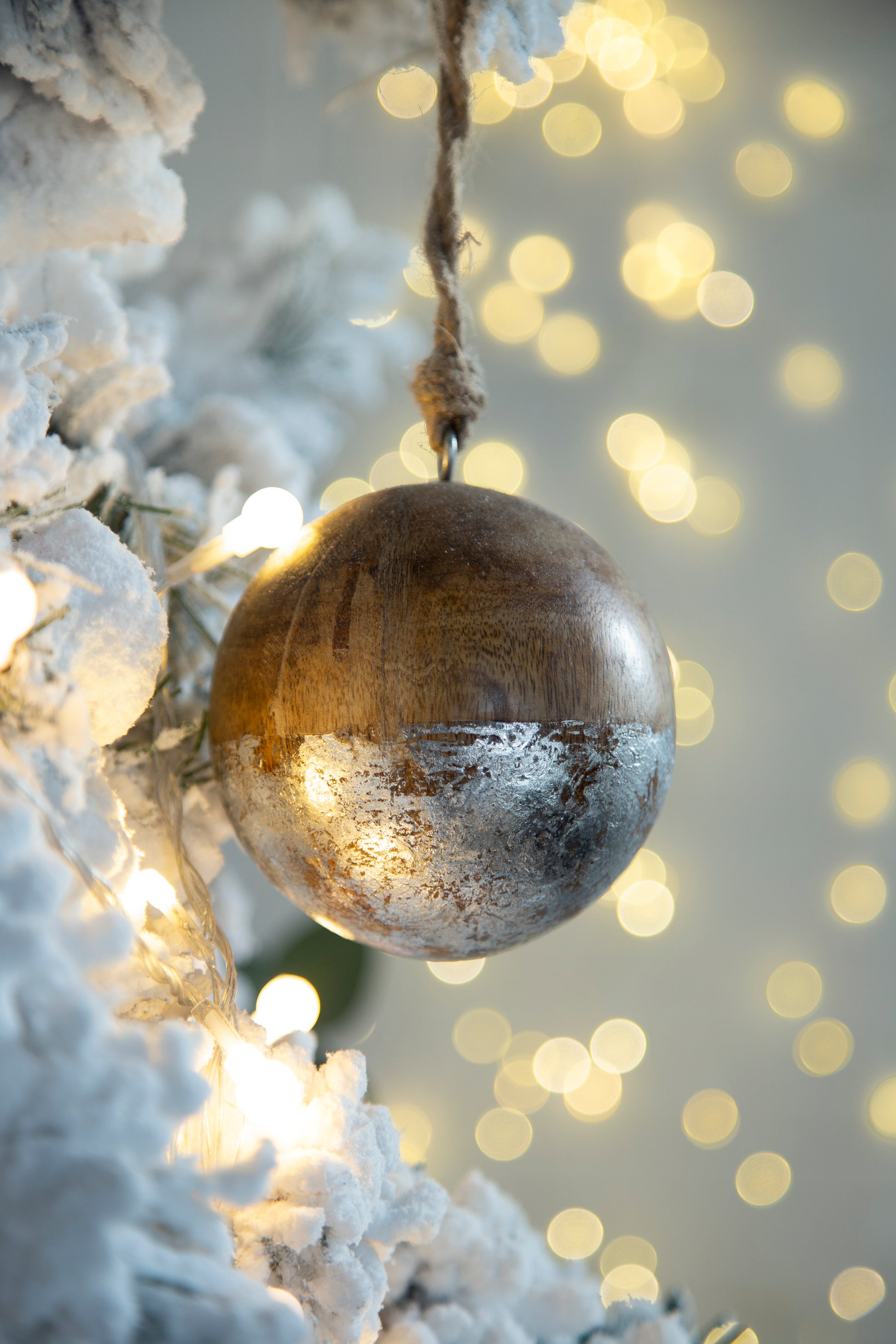 Rustic wooden Christmas ornament with silver leaf accent hung with twine