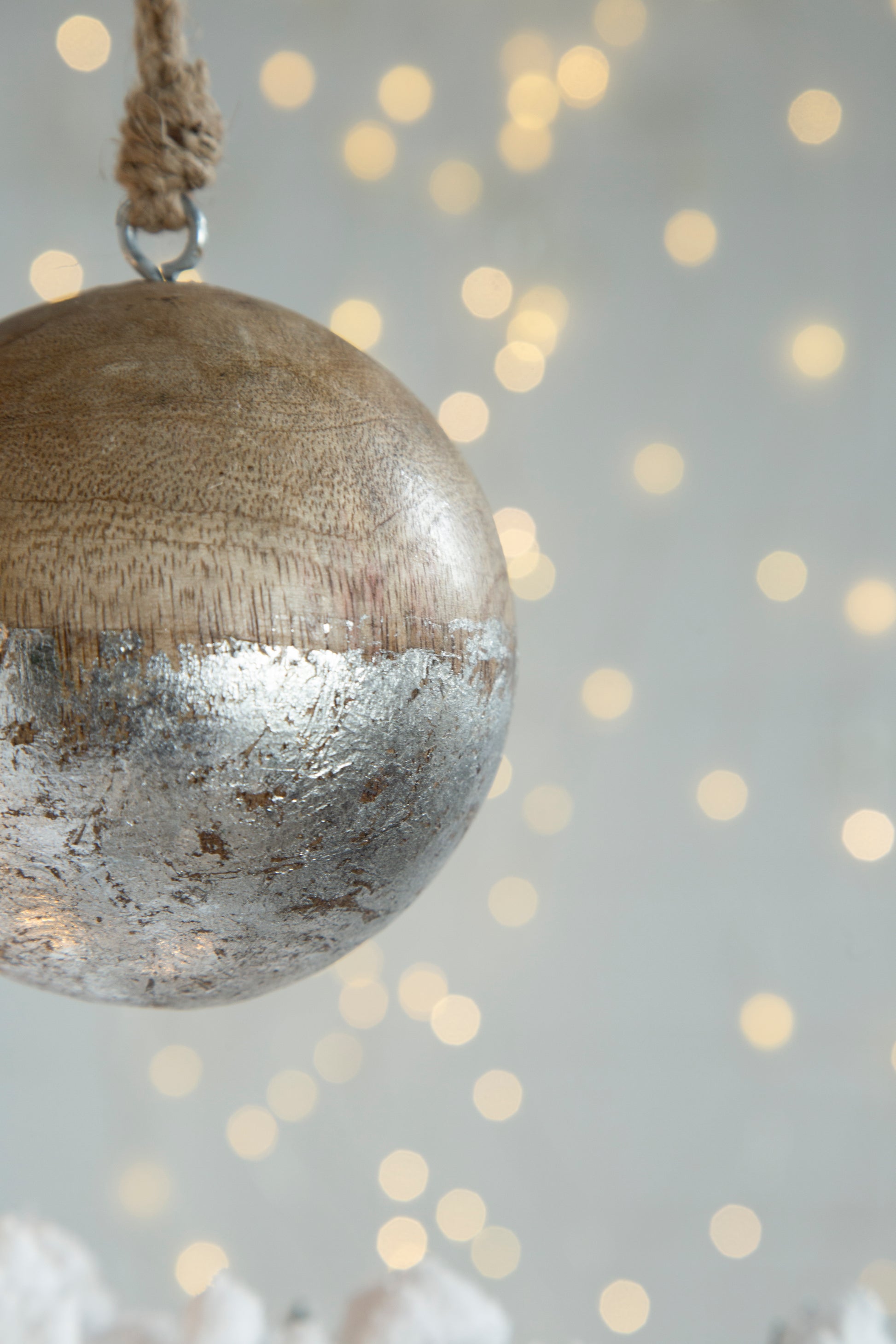 Rustic wooden sphere with distressed silver finish hanging by jute twine ideal for rustic decor