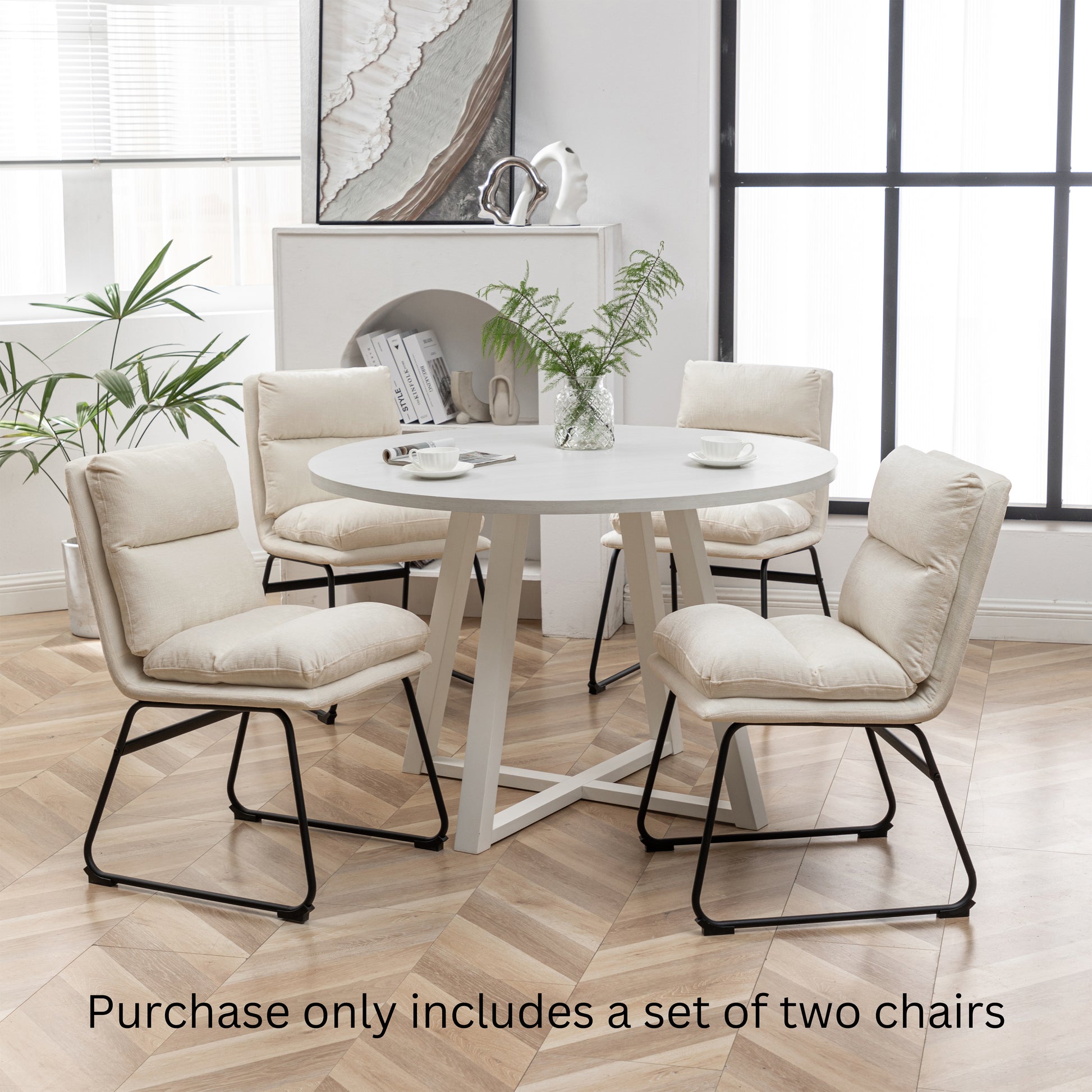Cream fabric dining chairs with black metal legs and plush cushions