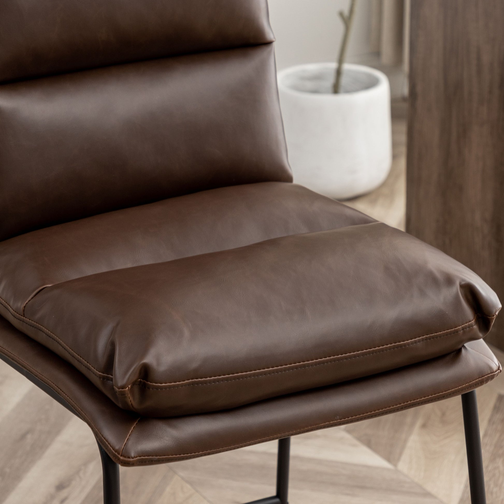 Rich brown vegan leather dining chair with cushioned seat and back
