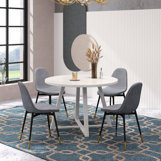 Round white dining table with four grey chairs and modern gold accents