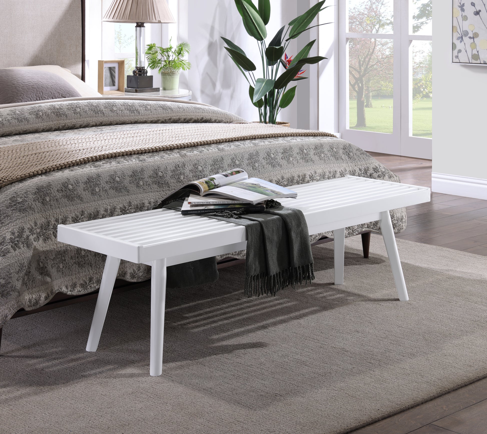 White slatted bench with tapered legs in a modern bedroom setting