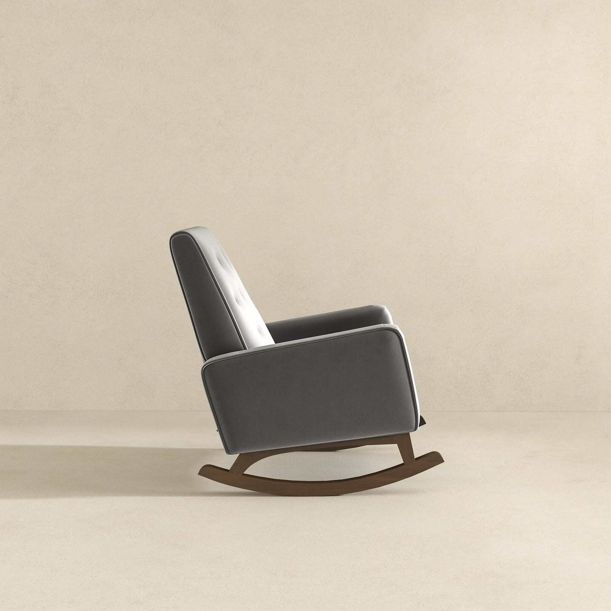 Grey upholstered rocking chair with tufted back and dark wood base