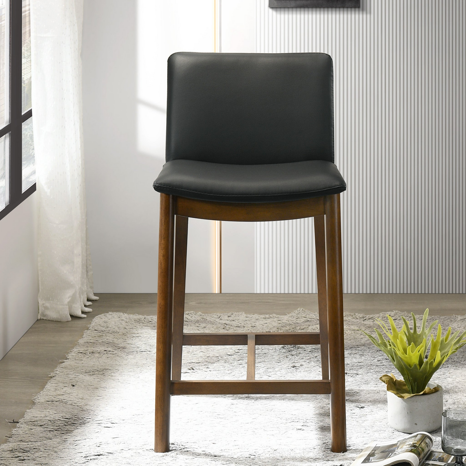 Black upholstered counter stool with a warm wood frame perfect for modern kitchens
