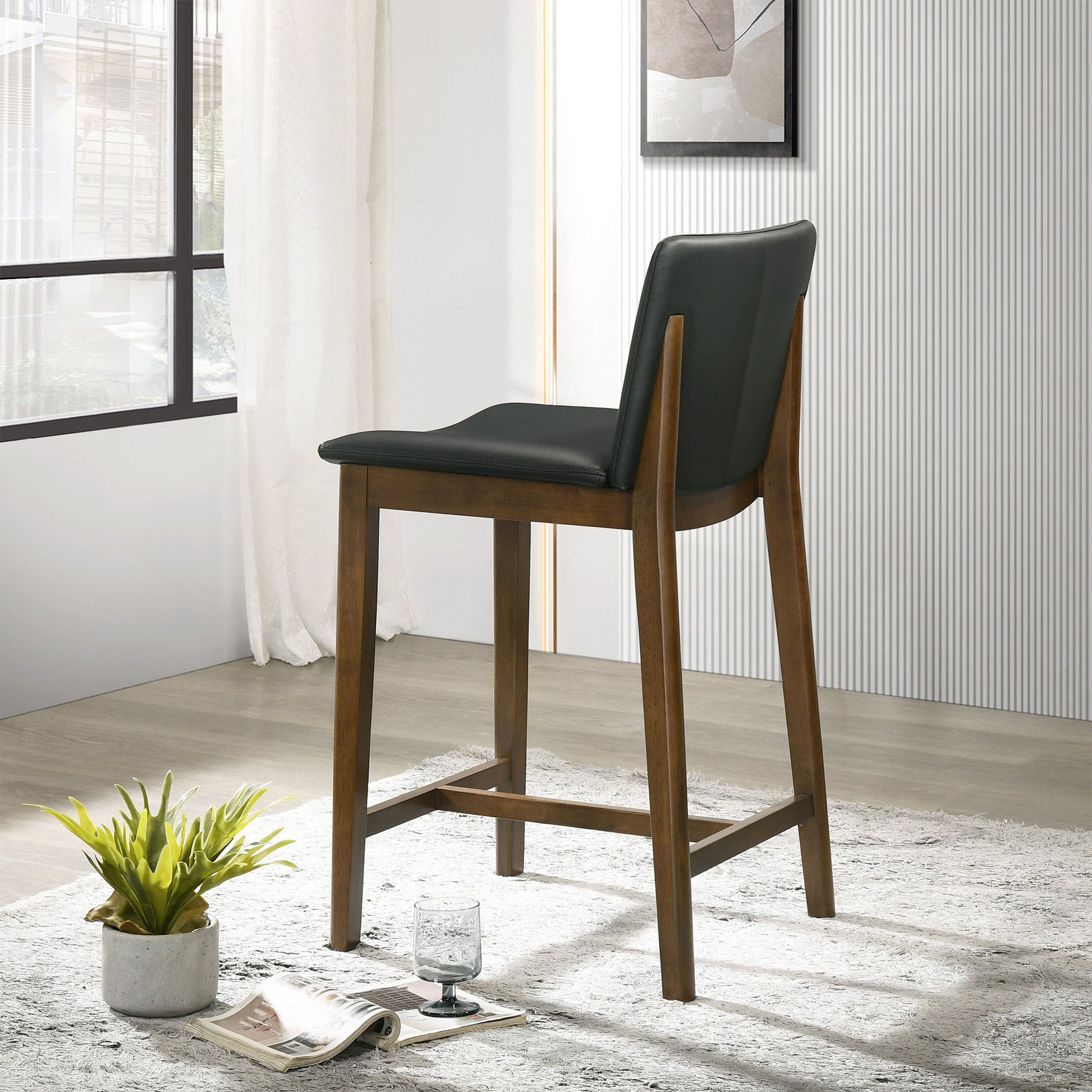 Modern black leatherette bar stool with a rich walnut wood frame perfect for kitchen islands