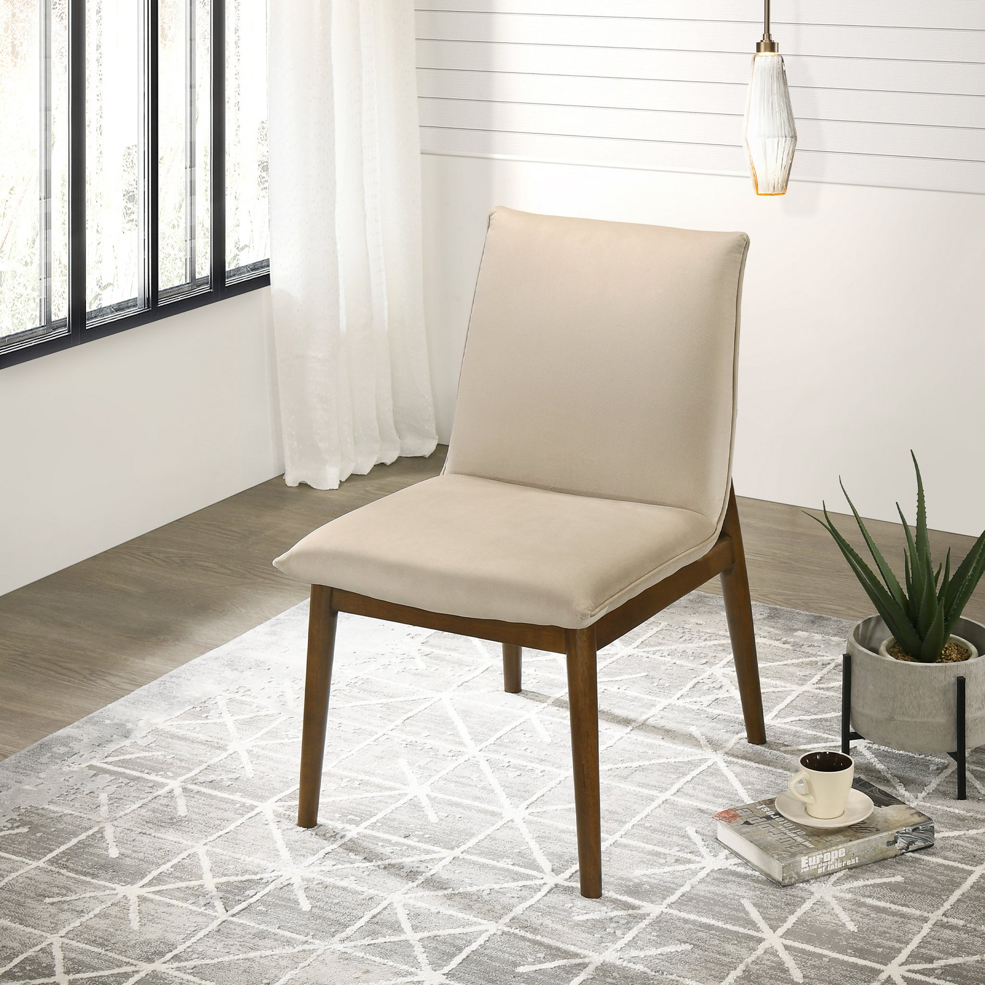 Beige upholstered dining chair with wooden legs on a geometric rug
