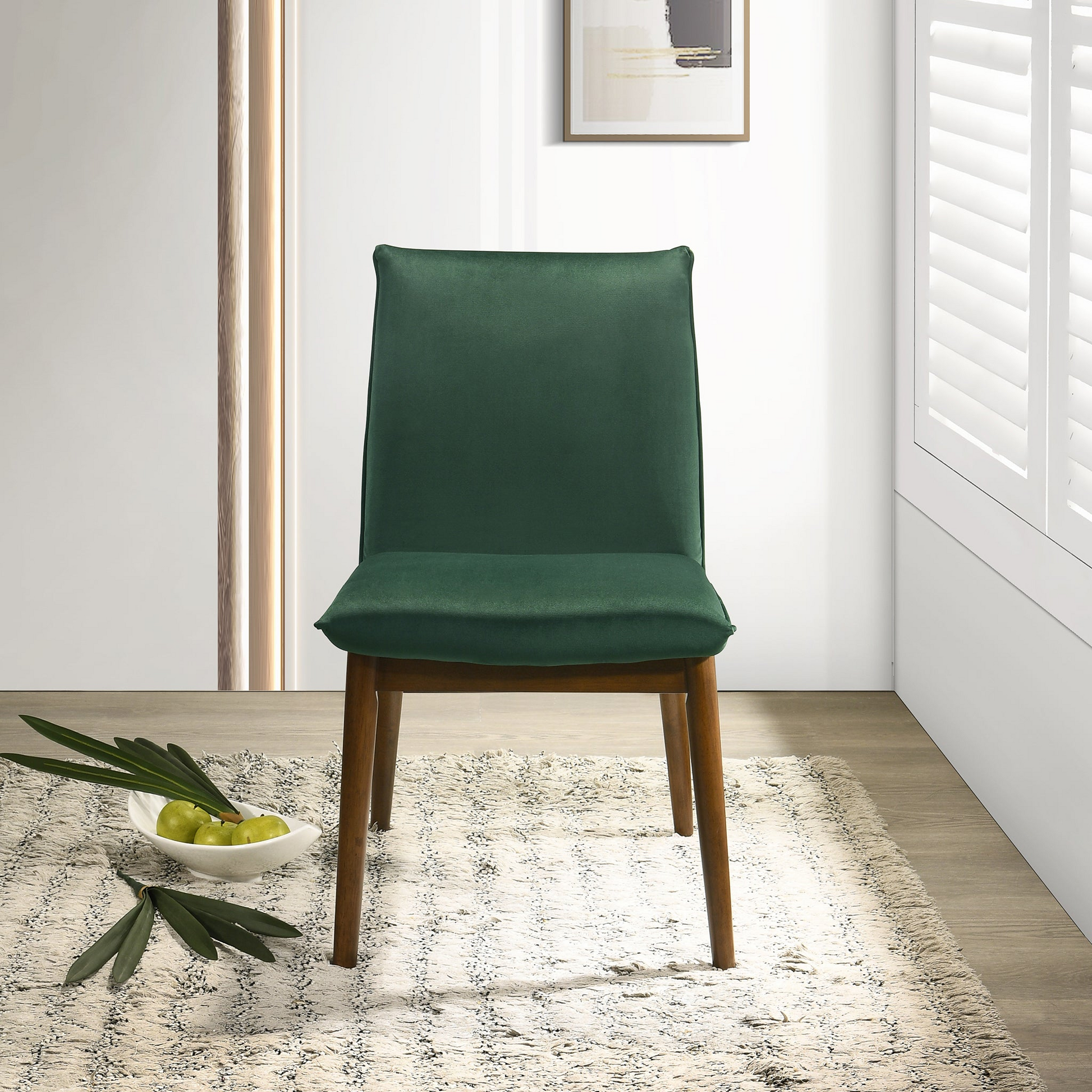 Emerald green velvet dining chair with dark wood legs minimalist design