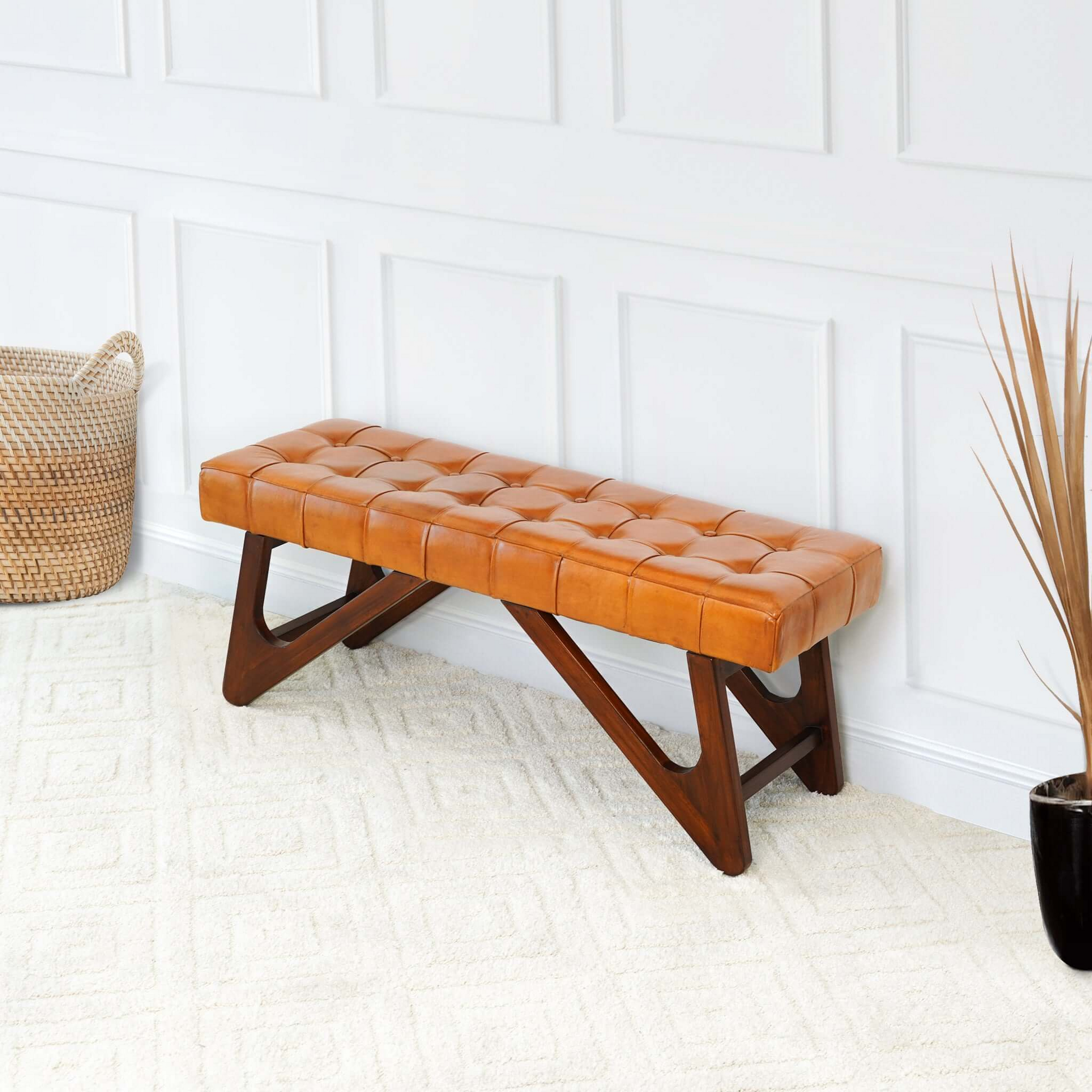 Tufted tan leather bench with dark wood angular legs perfect for entryways or living rooms