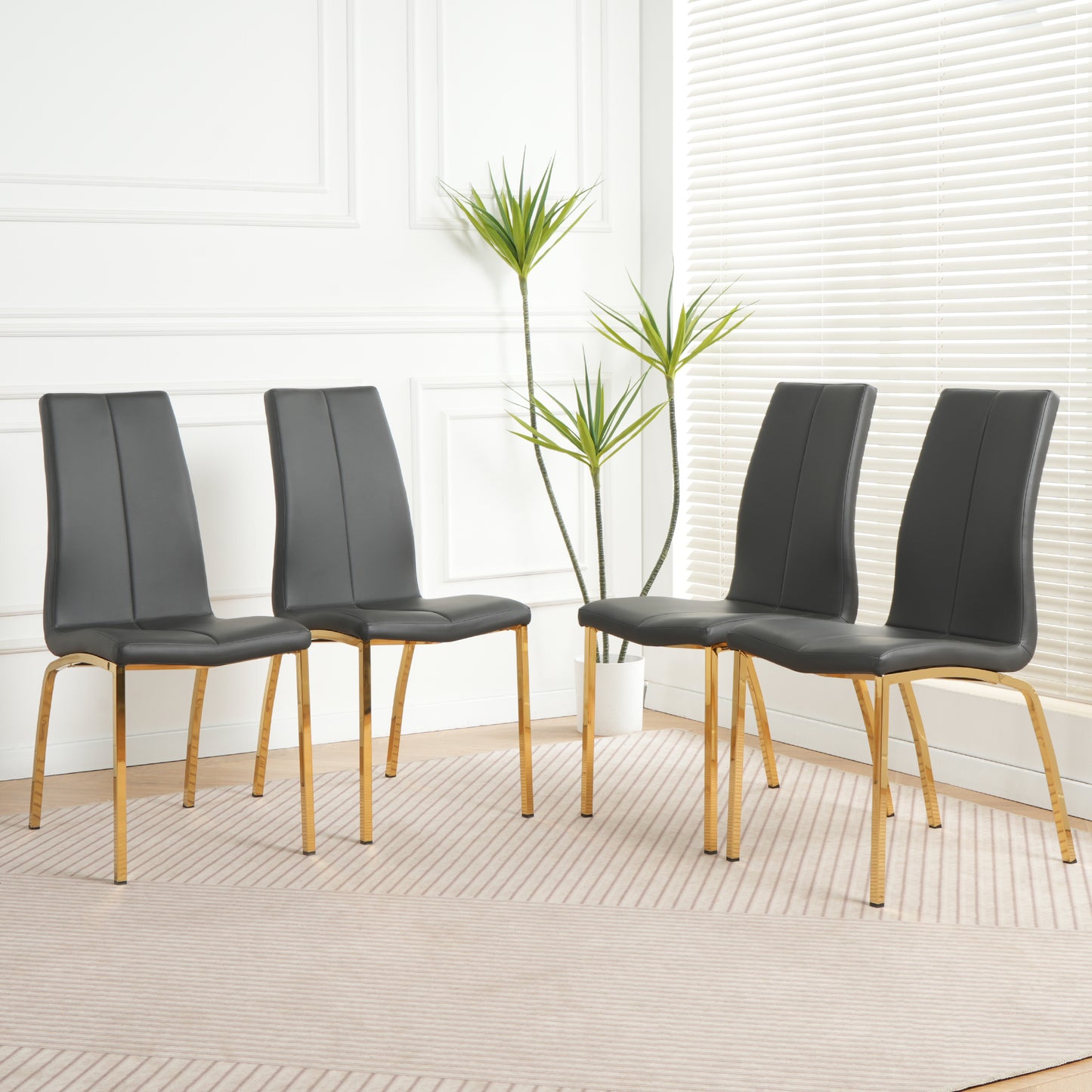 Four dark gray faux leather dining chairs with gold legs