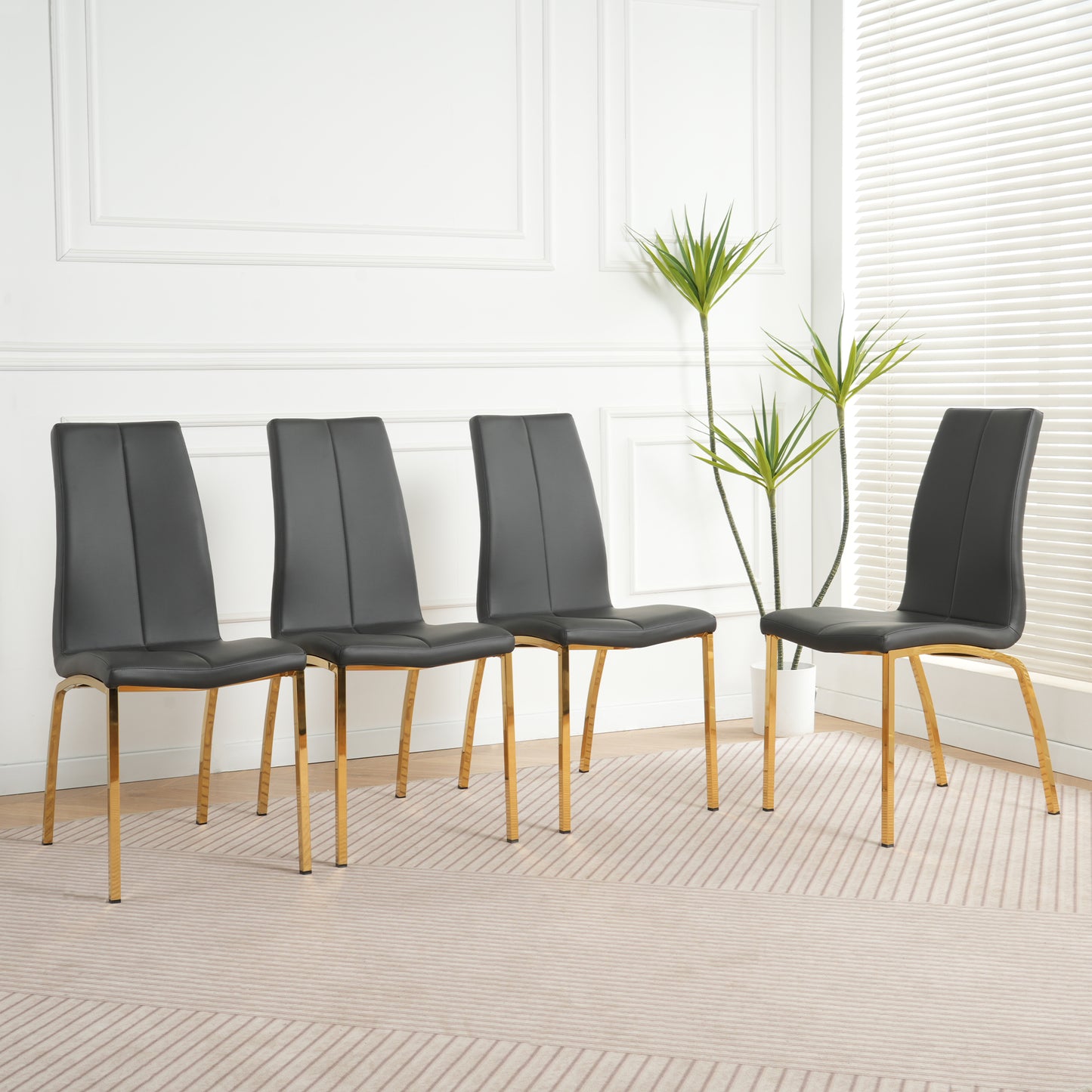 Four black faux leather dining chairs with gold metal legs