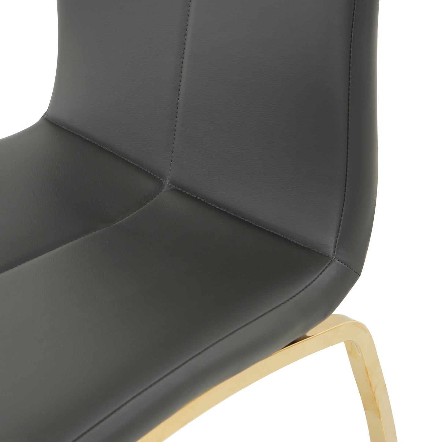 Closeup of a dark gray faux leather dining chair with elegant gold metal legs