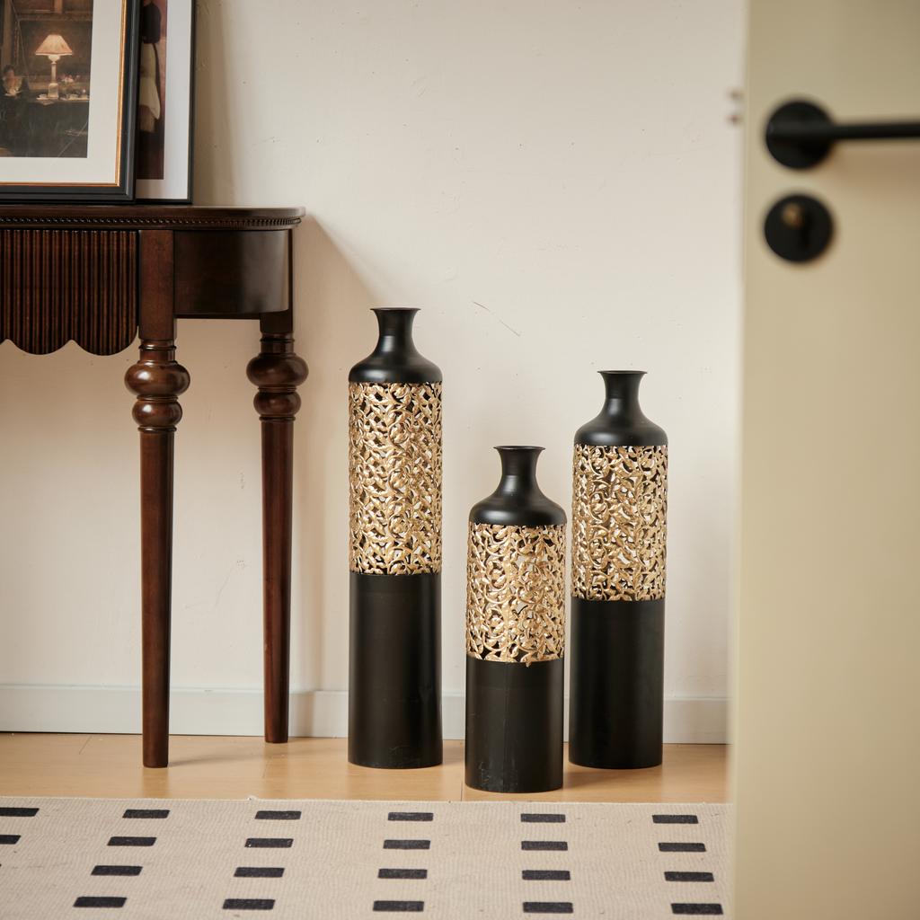 Tall black metal vase with ornate gold filigree overlay for entryway decor