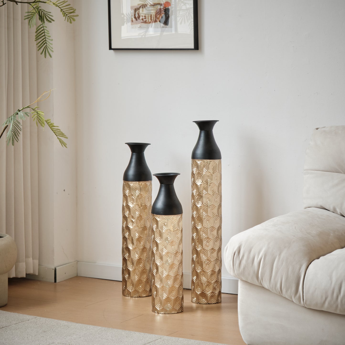 Set of three tall gold vases with textured geometric patterns and black tops