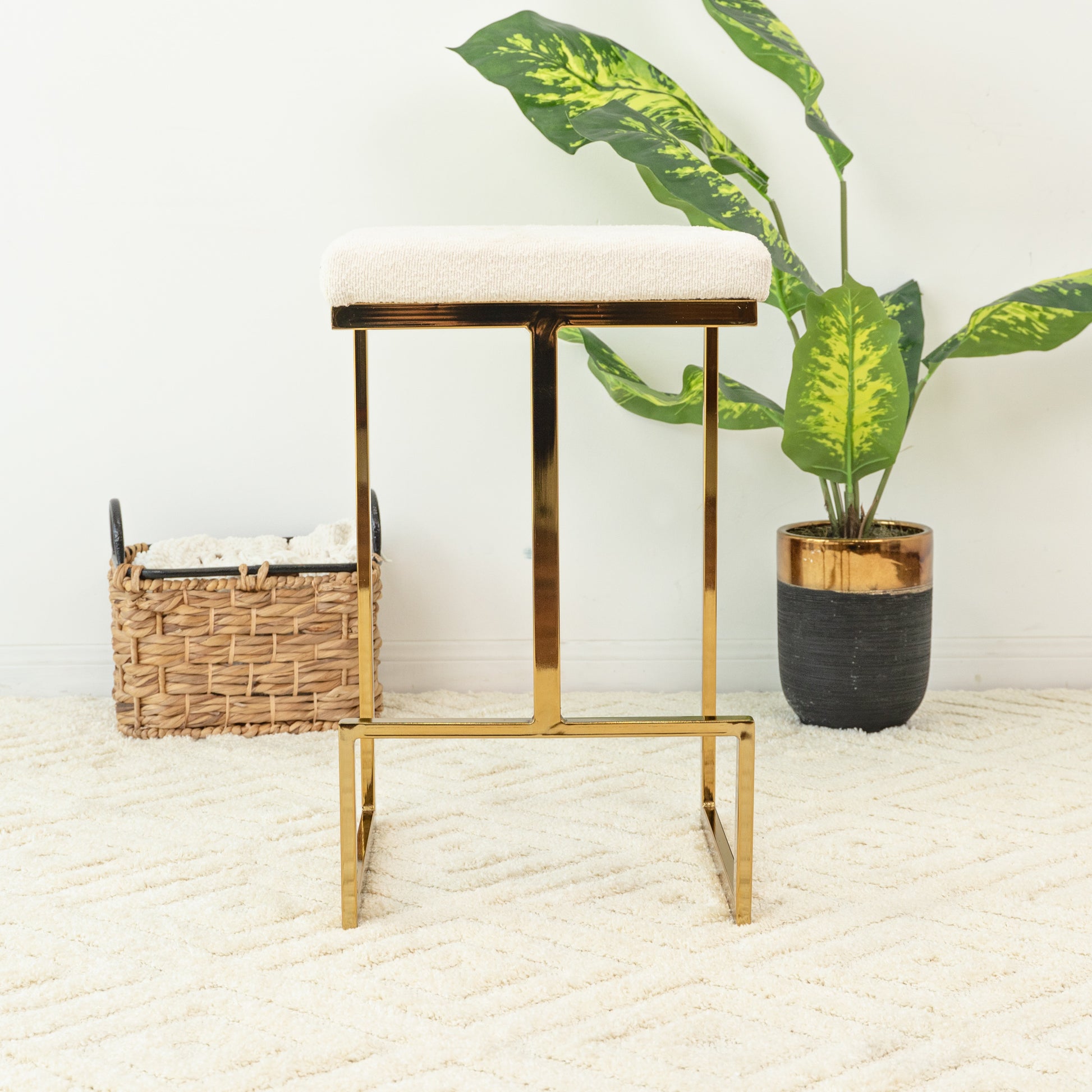 Cream boucle upholstered bar stool with a gold metal frame and footrest