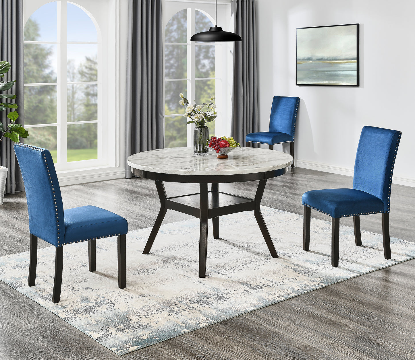 Round marbletop dining table with dark wood base and three upholstered blue velvet chairs