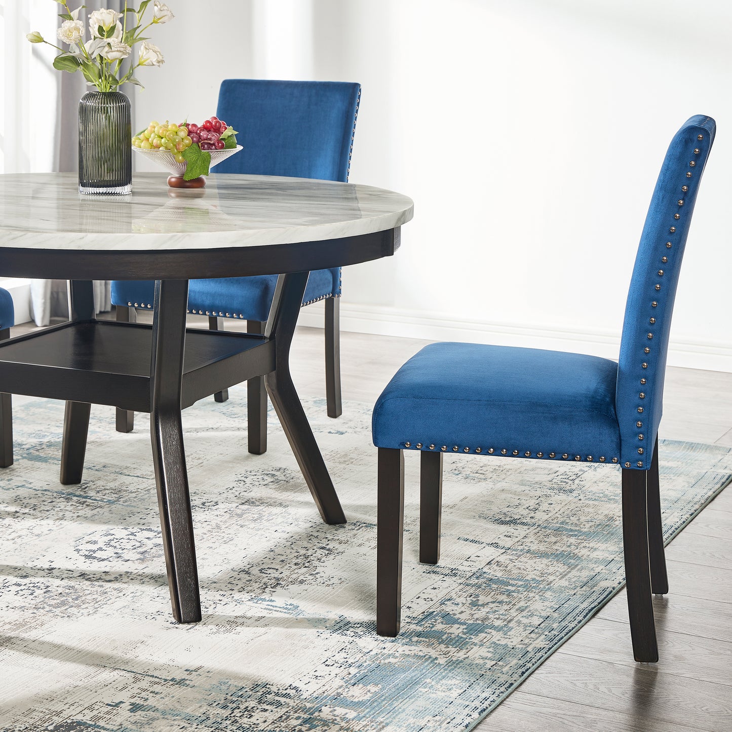 Deep blue velvet dining chair with silver nailhead trim and dark wood legs