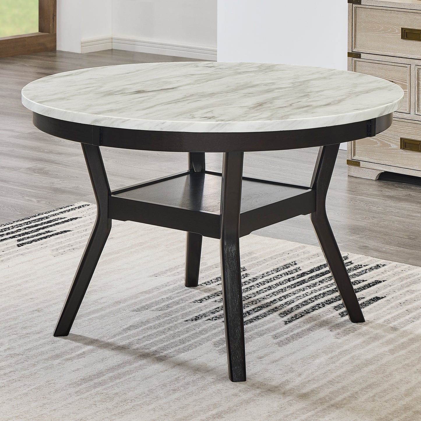 Round faux marble dining table with dark wood legs and a lower shelf