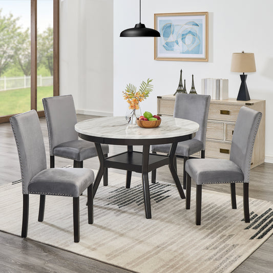 Round marble dining table with four grey velvet chairs with silver nailhead trim