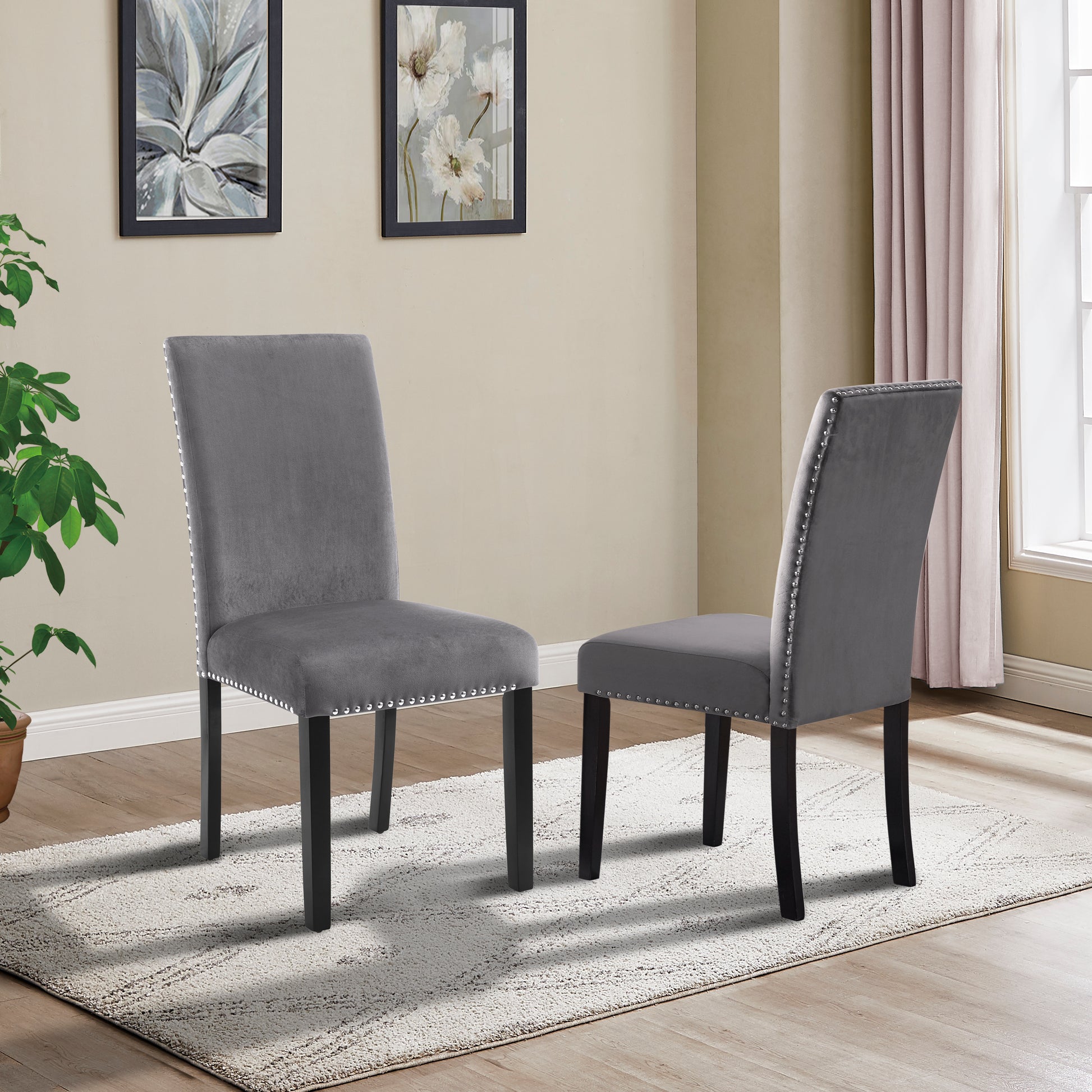 Grey velvet dining chair with silver nailhead trim and dark wood legs