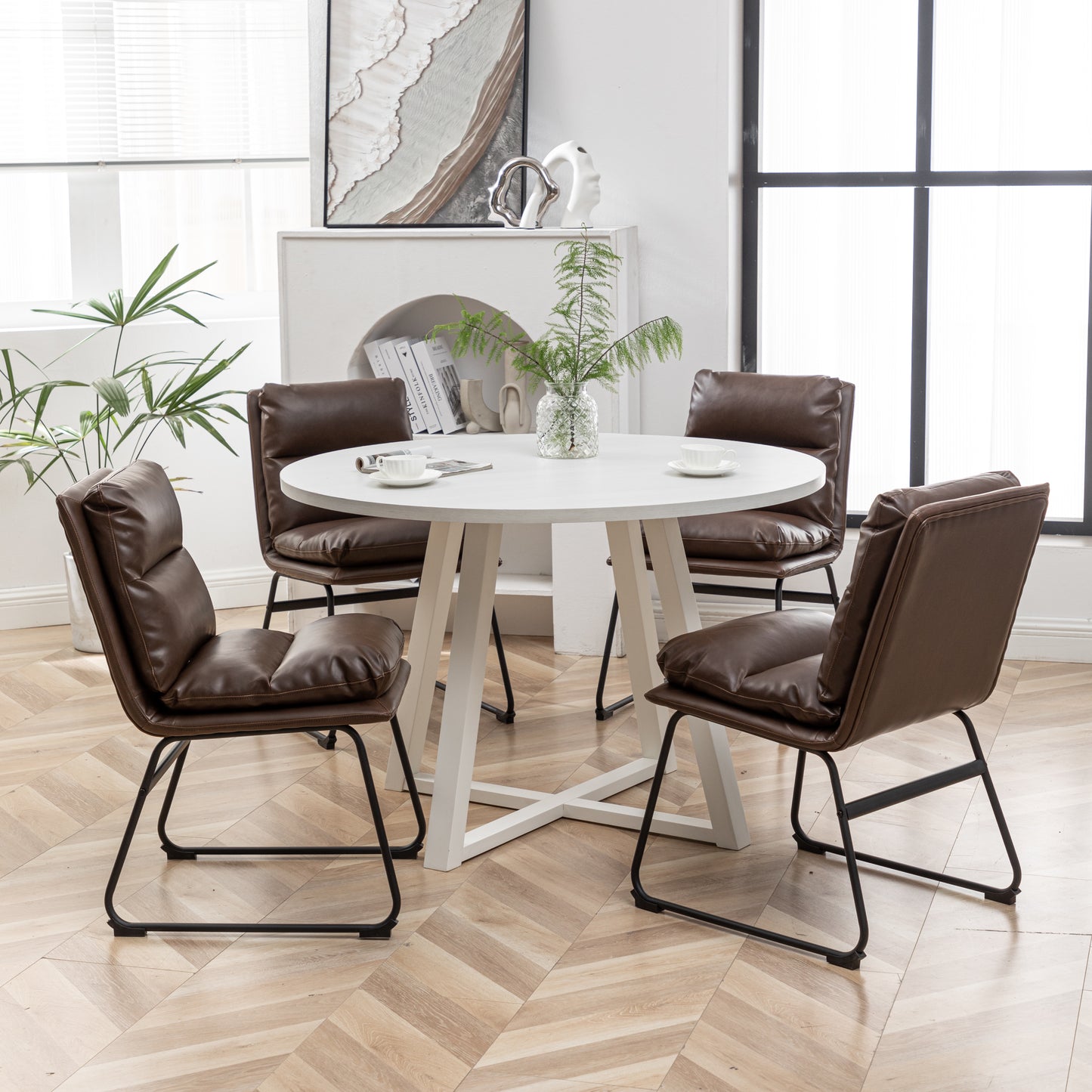 Set of  brown faux leather dining chairs with black metal legs arranged around a white round table