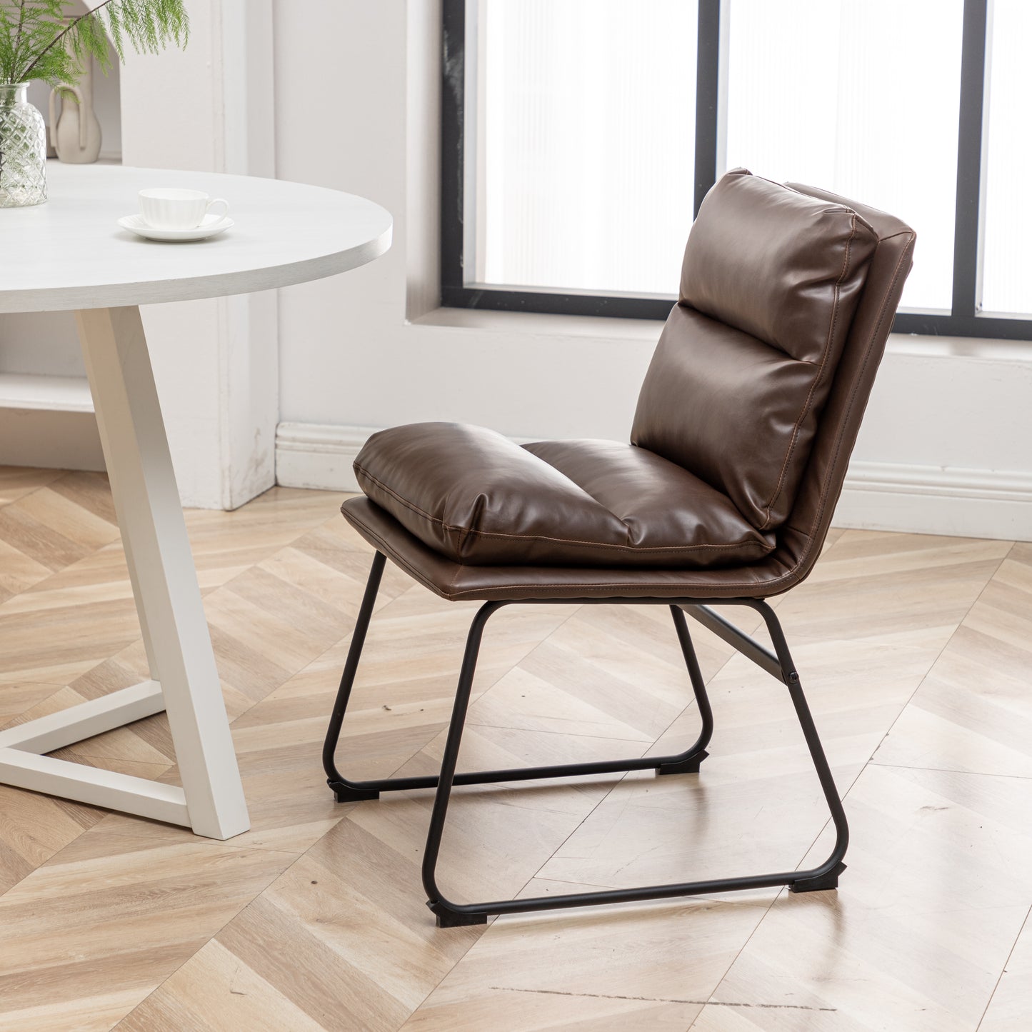 Brown faux leather accent chair with plush cushioning and black metal legs perfect for modern living spaces