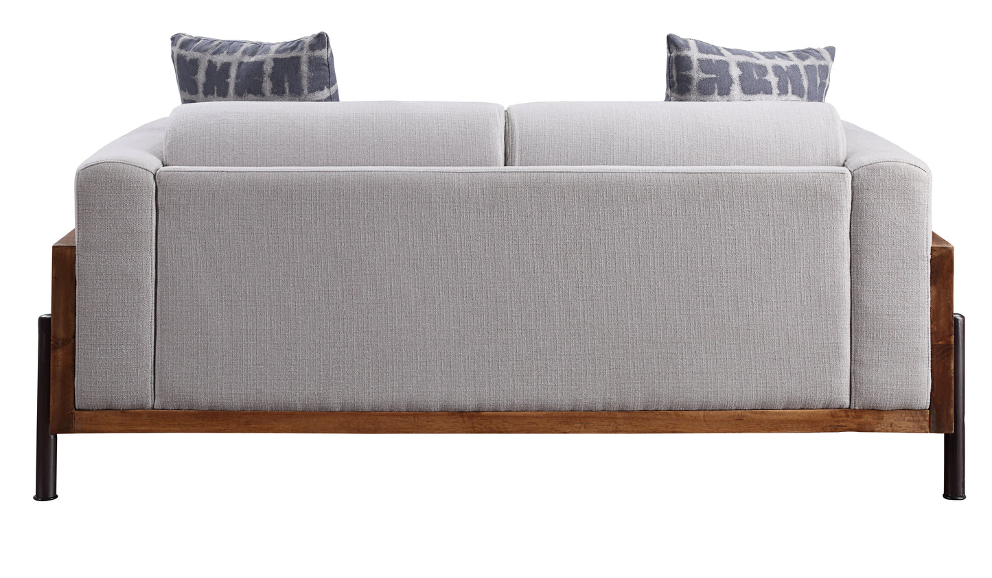 Light grey fabric sofa with geometric print pillows and dark wood frame