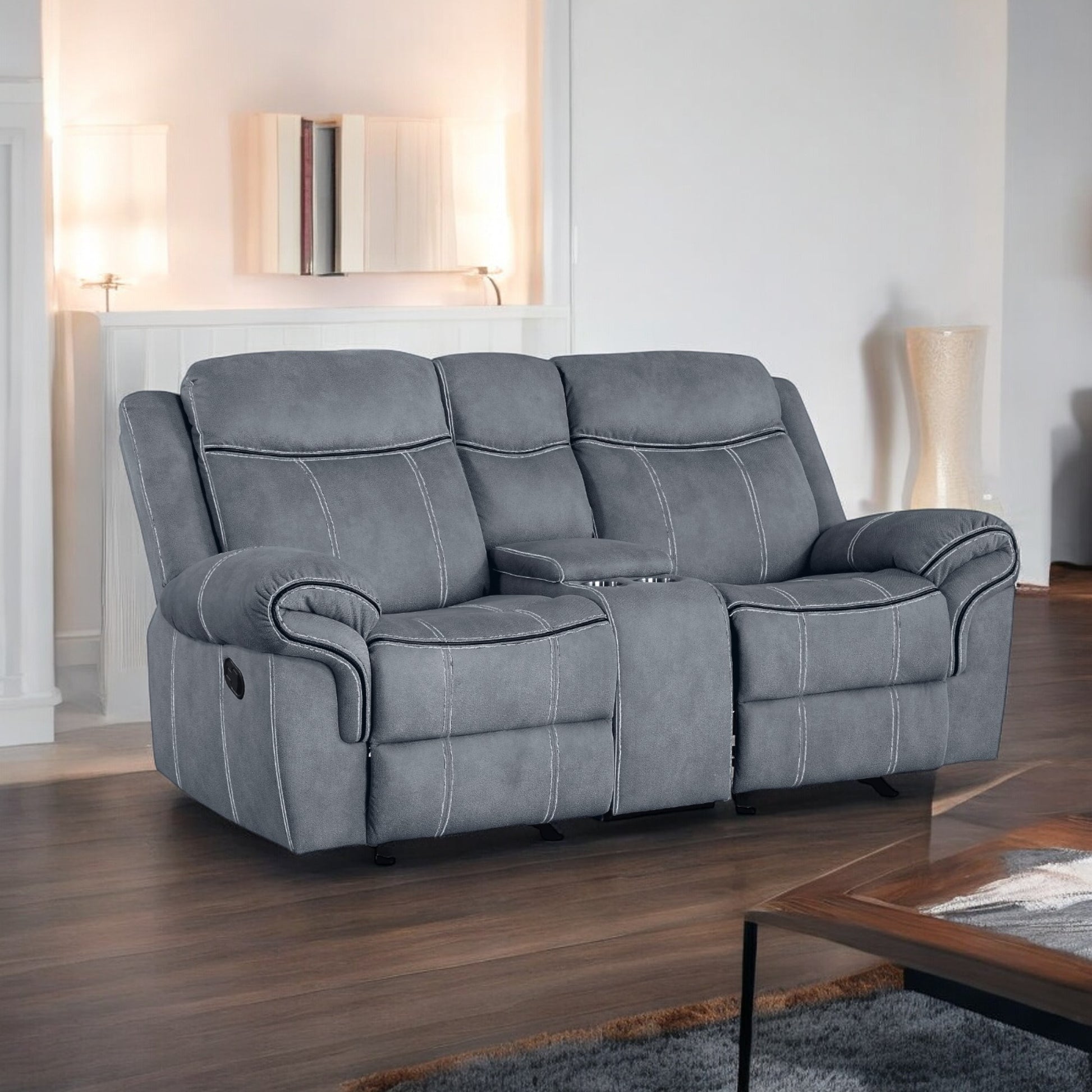 Gray reclining loveseat with white stitching and builtin cup holders