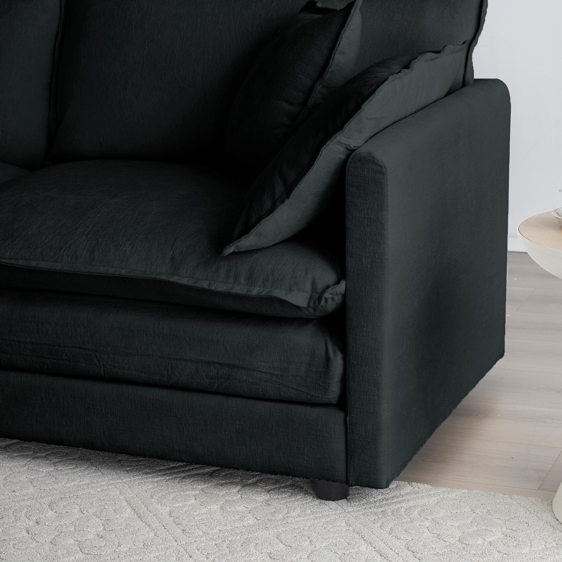 Closeup of a dark gray linen couch with plush cushions and a textured fabric ideal for modern living rooms