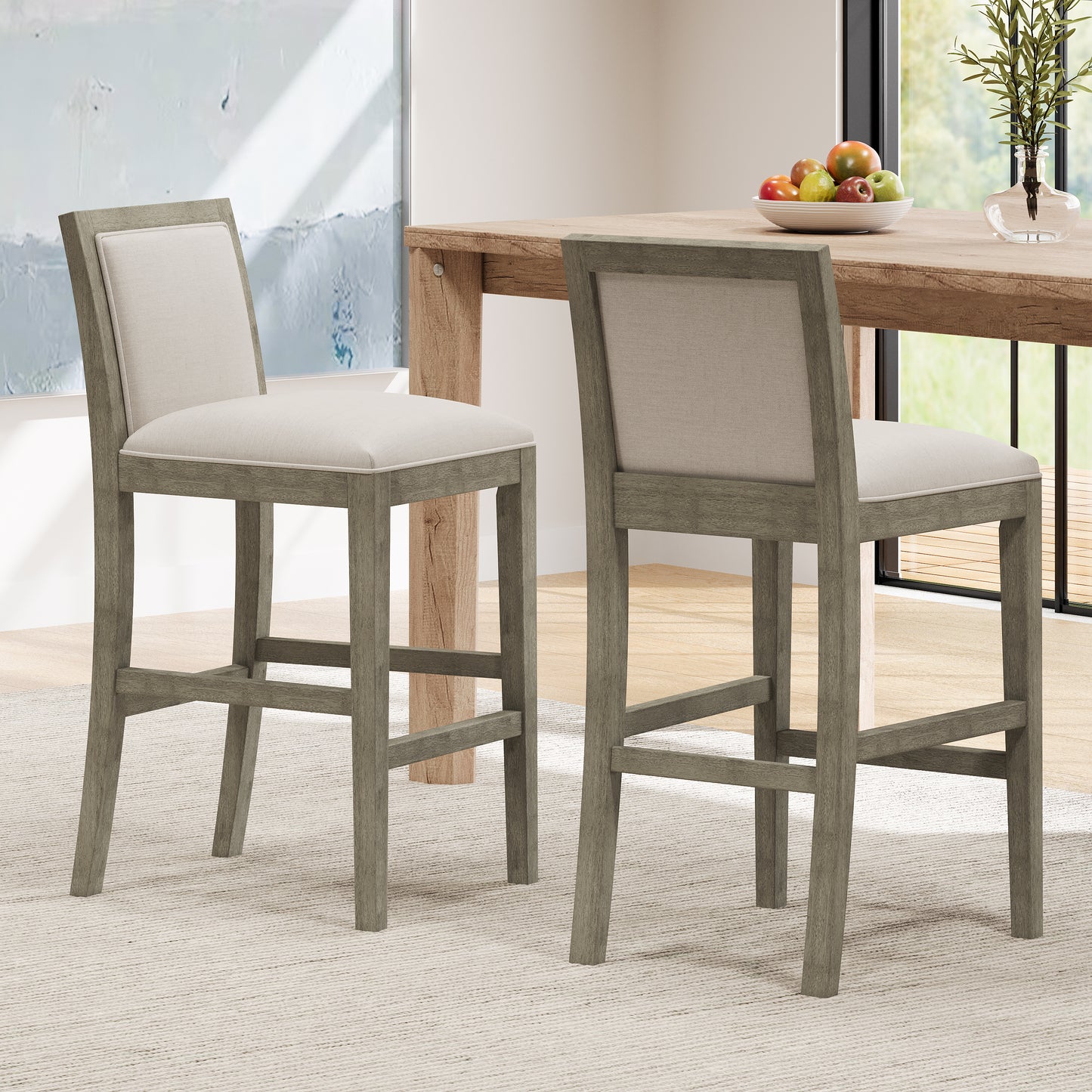 Two gray wood and beige fabric bar stools beside a rustic dining table