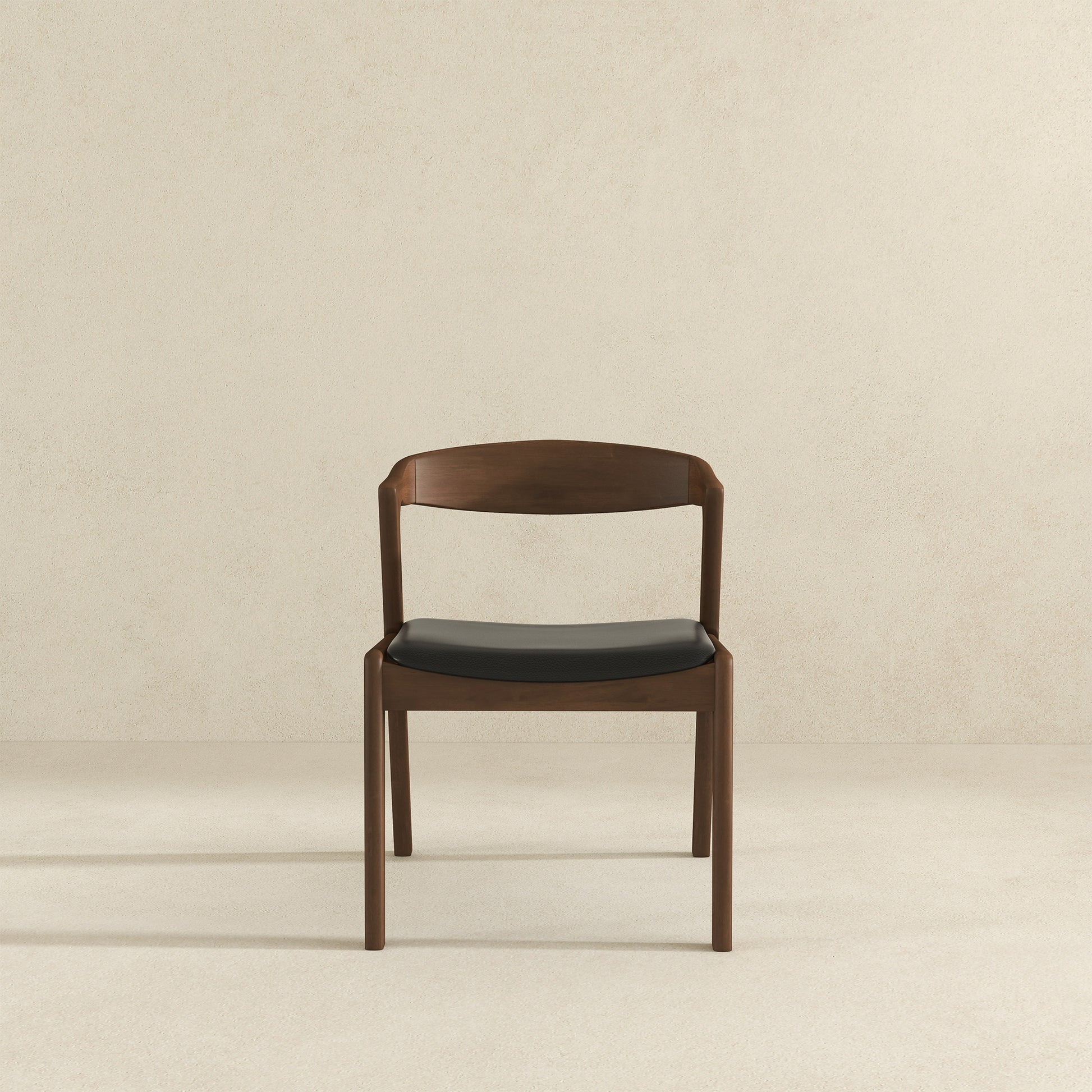 Modern walnut dining chair with a black upholstered seat and curved back
