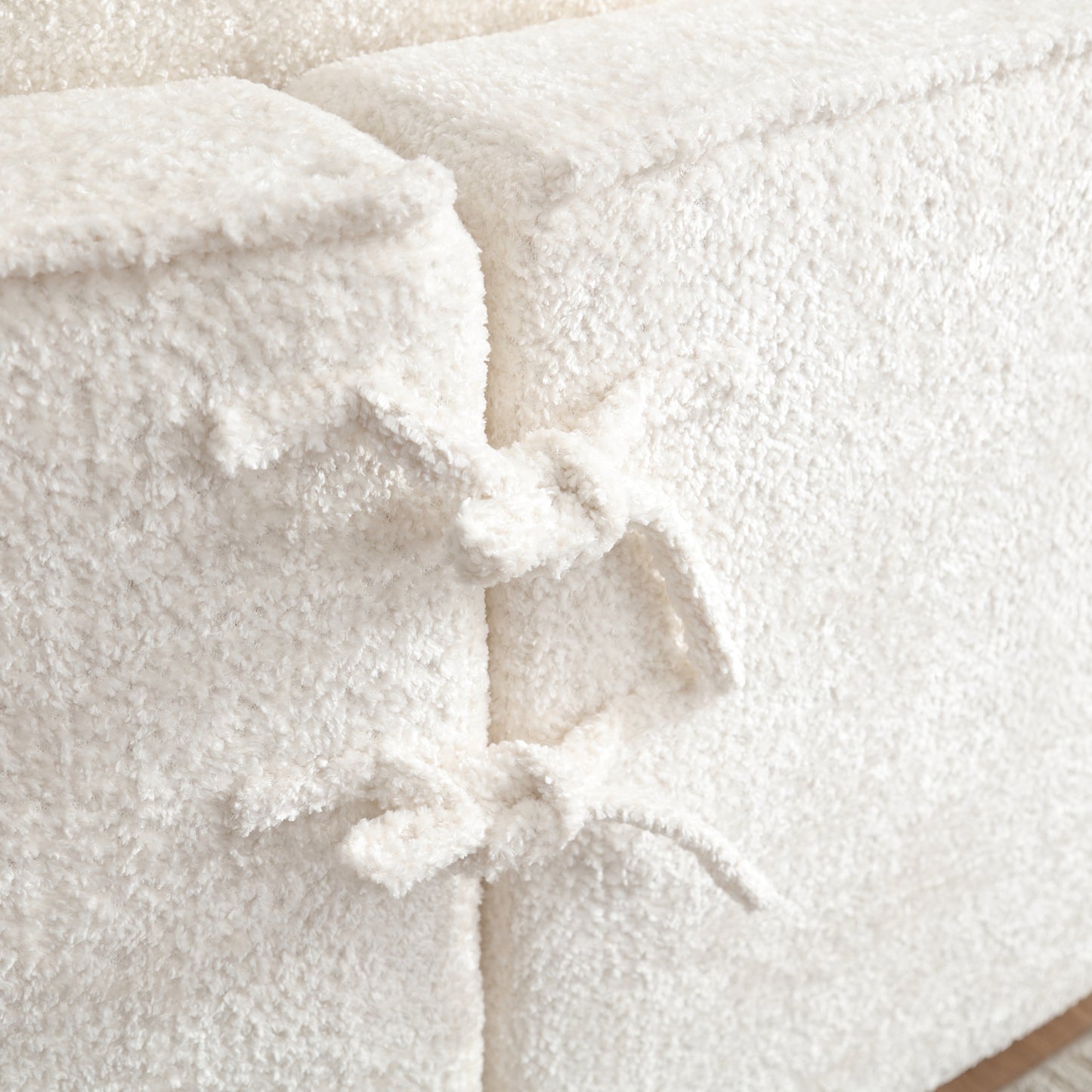 Creamy sherpa fabric ottoman with tie detail for cozy seating
