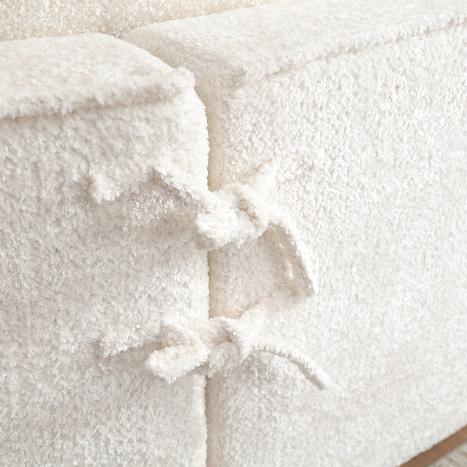 Creamy sherpa fabric ottoman with tie detail for cozy seating