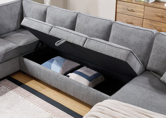 Gray sectional sofa with lifttop storage compartment revealing two decorative pillows