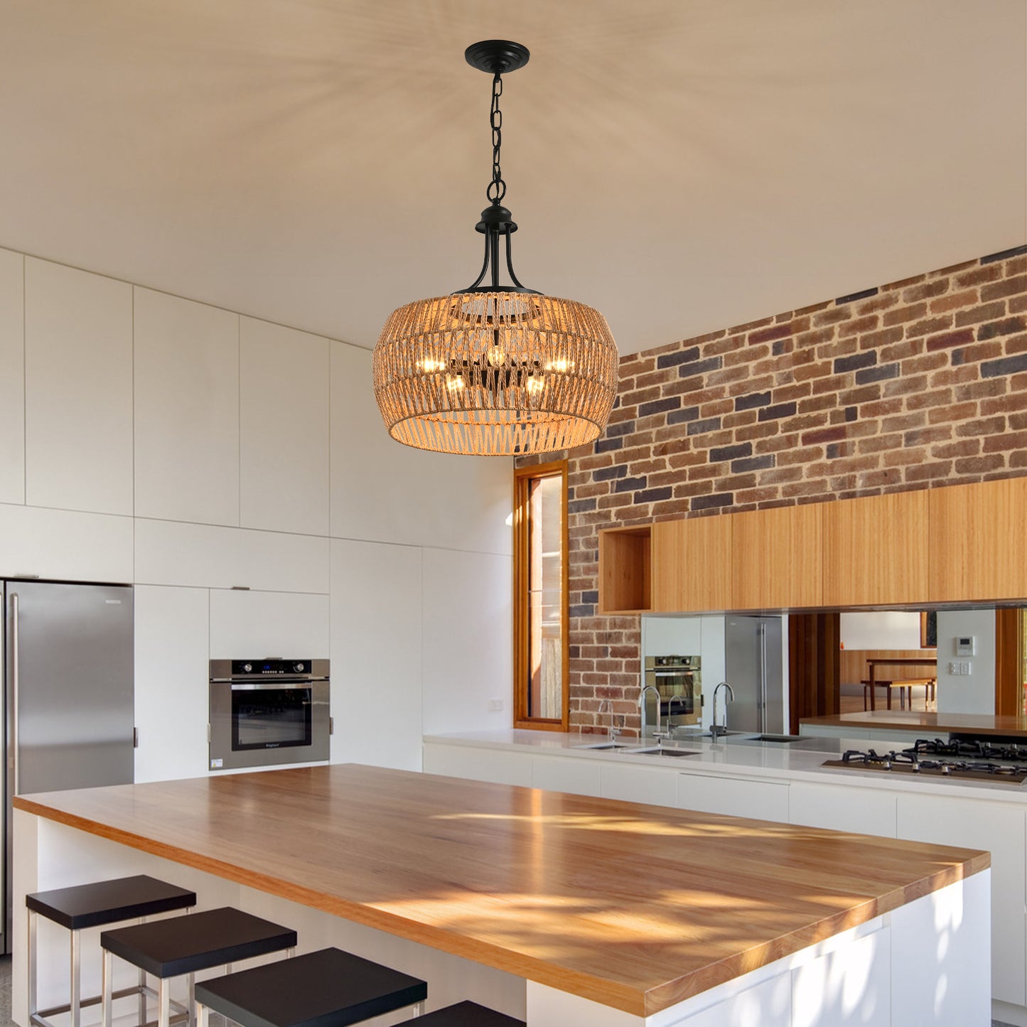 Rattan drum chandelier with black metal accents casting warm light over modern kitchen island