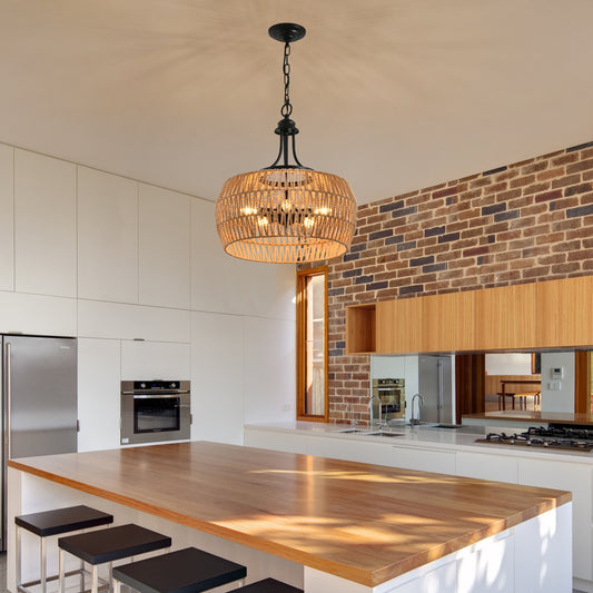 Rattan drum chandelier with black metal accents casting warm light over modern kitchen island