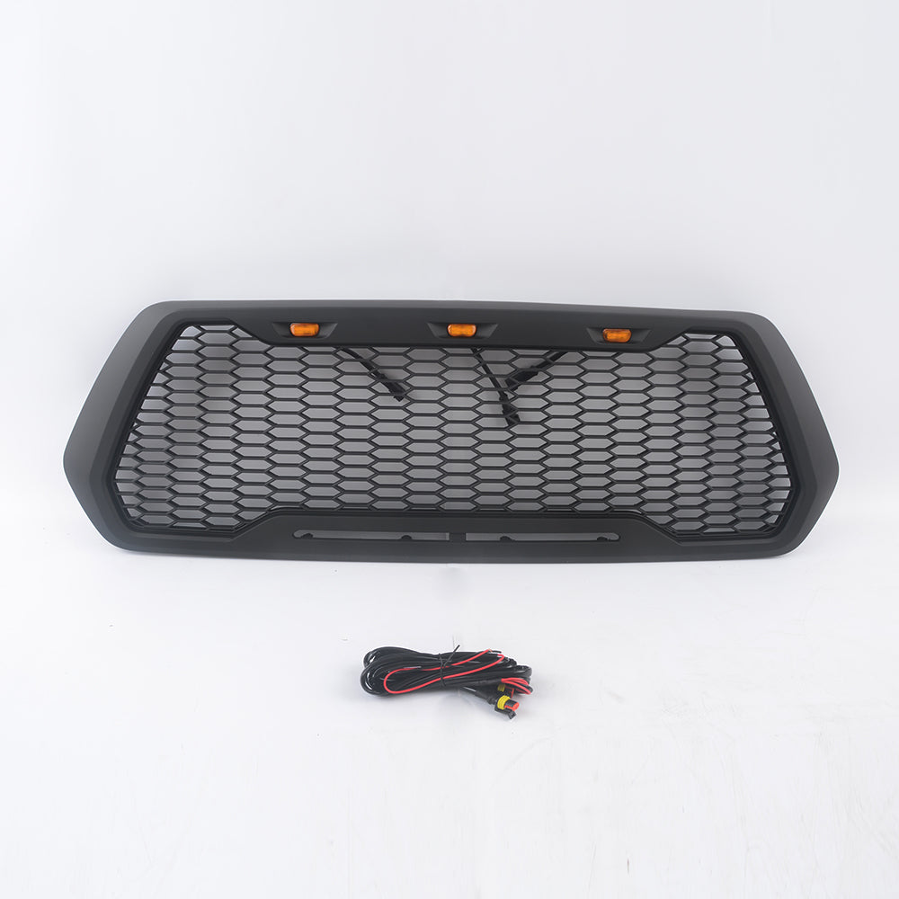 Matte black TRD style truck grille with amber LED lights and wiring harness