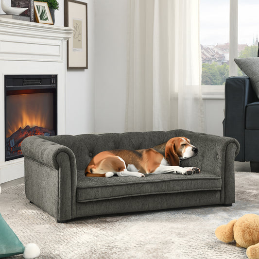 A beagle dog rests on a plush dark grey tufted pet sofa with rolled arms