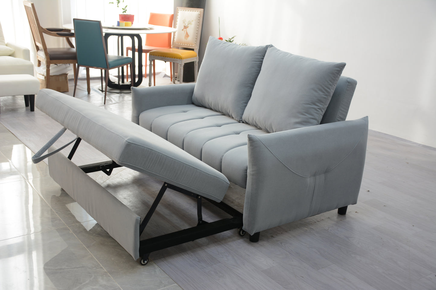 Grey fabric sofa bed with tufted cushions and pullout footrest for comfortable lounging