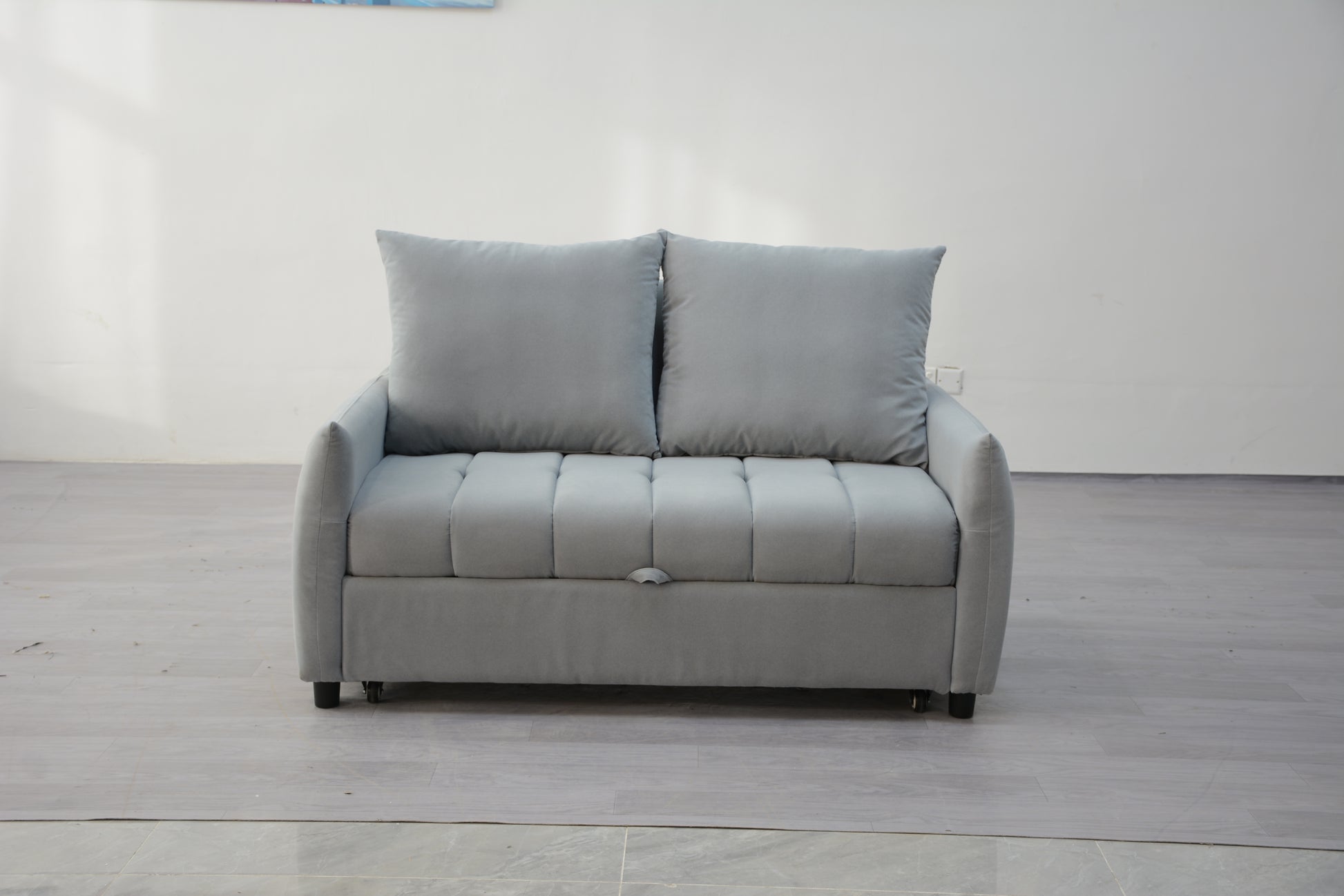 Light grey velvet sofa bed with two plush cushions perfect for small spaces